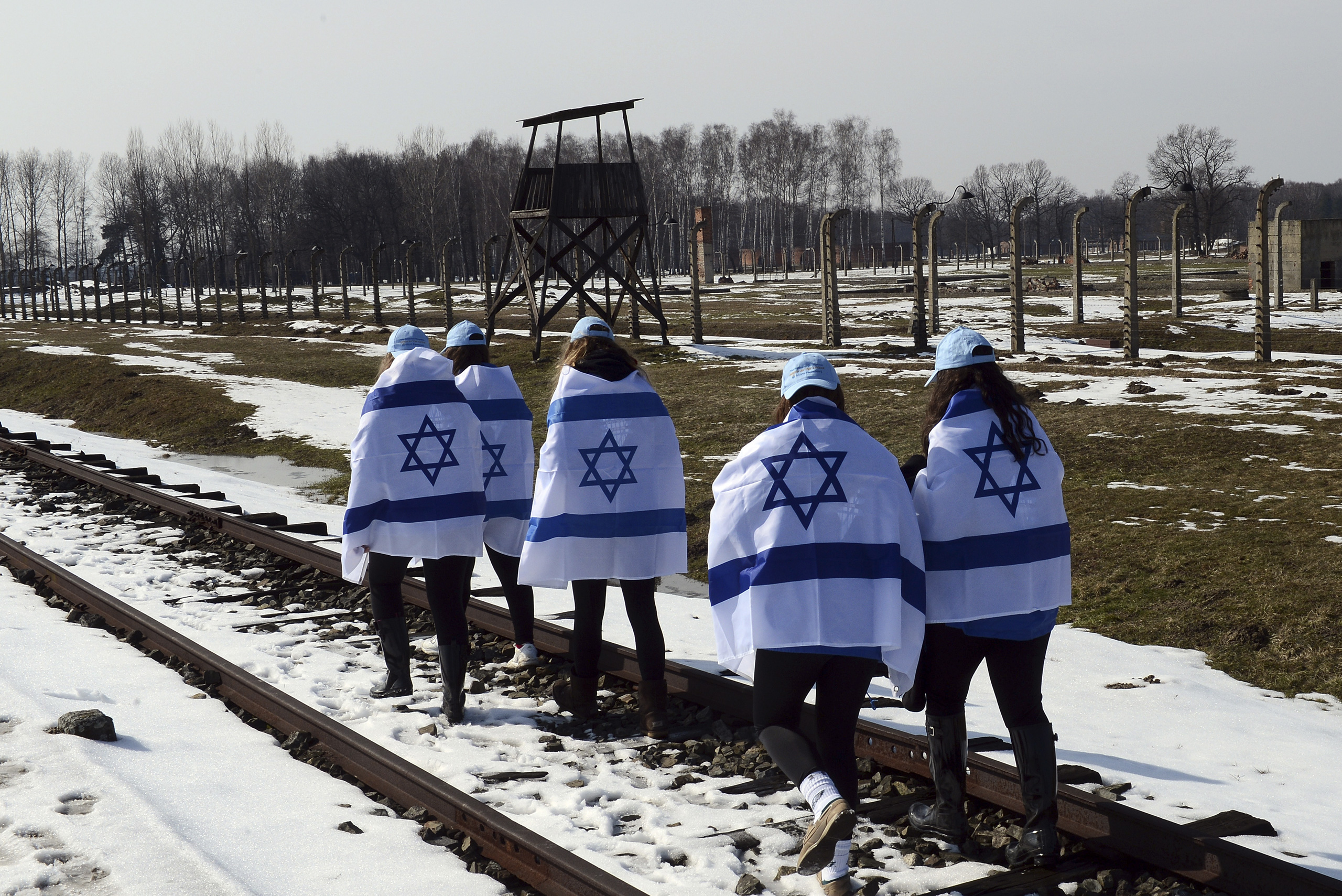 Participants of the annual "March of the Living" carry the Israeli flag wrapped around their shoulders as they walk along the rail road of the Auschwitz-Birkenau concentration camp in Oswiecim, Poland, April 8, 2013. (Janek Skarzynski—AFP/Getty Images)