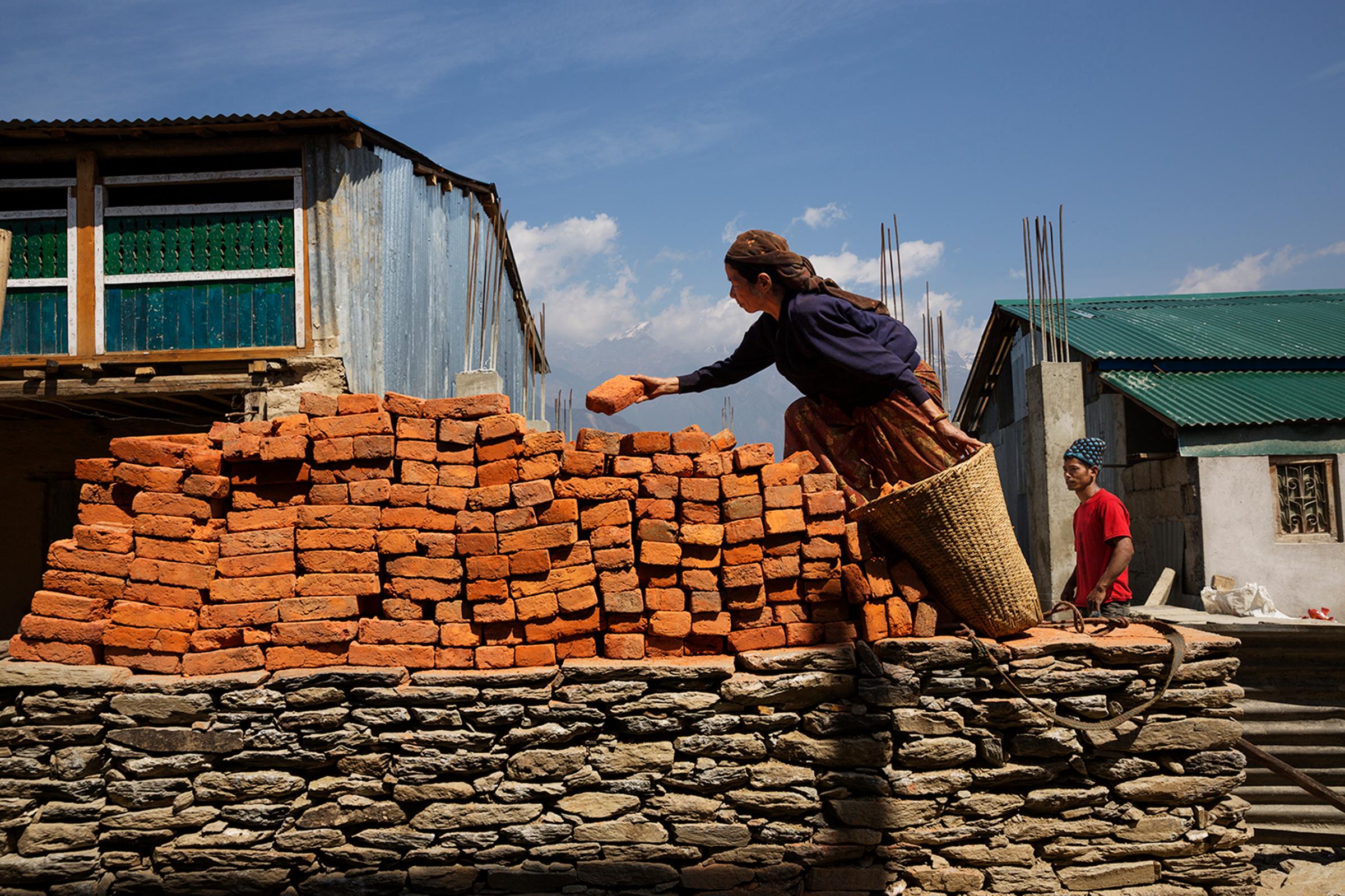 Villagers work at rebuilding a year after the devastating earthquakes of 2015 in Barpak, in Gorkha district, Nepal, April 6, 2016.