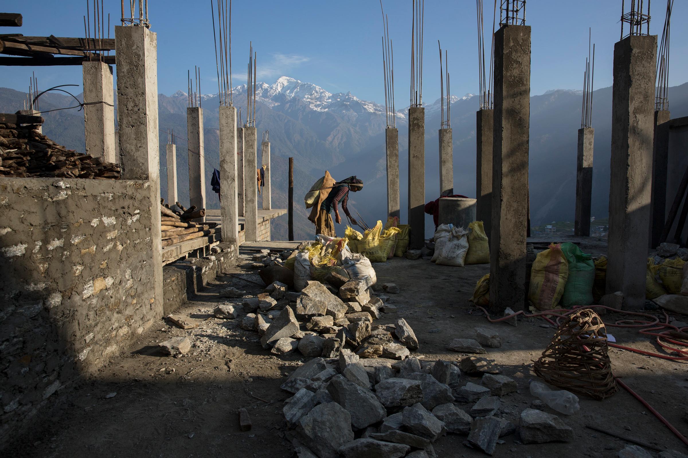 The village of Barpak, in Gorkha district, close to the epicenter of the earthquake, which destroyed almost the entire village. Villagers rebuilding houses and pathways and building a new religious stupa. Much of the work is accomplished communally. Buddha Himal mountain in background.by James Nachtwey