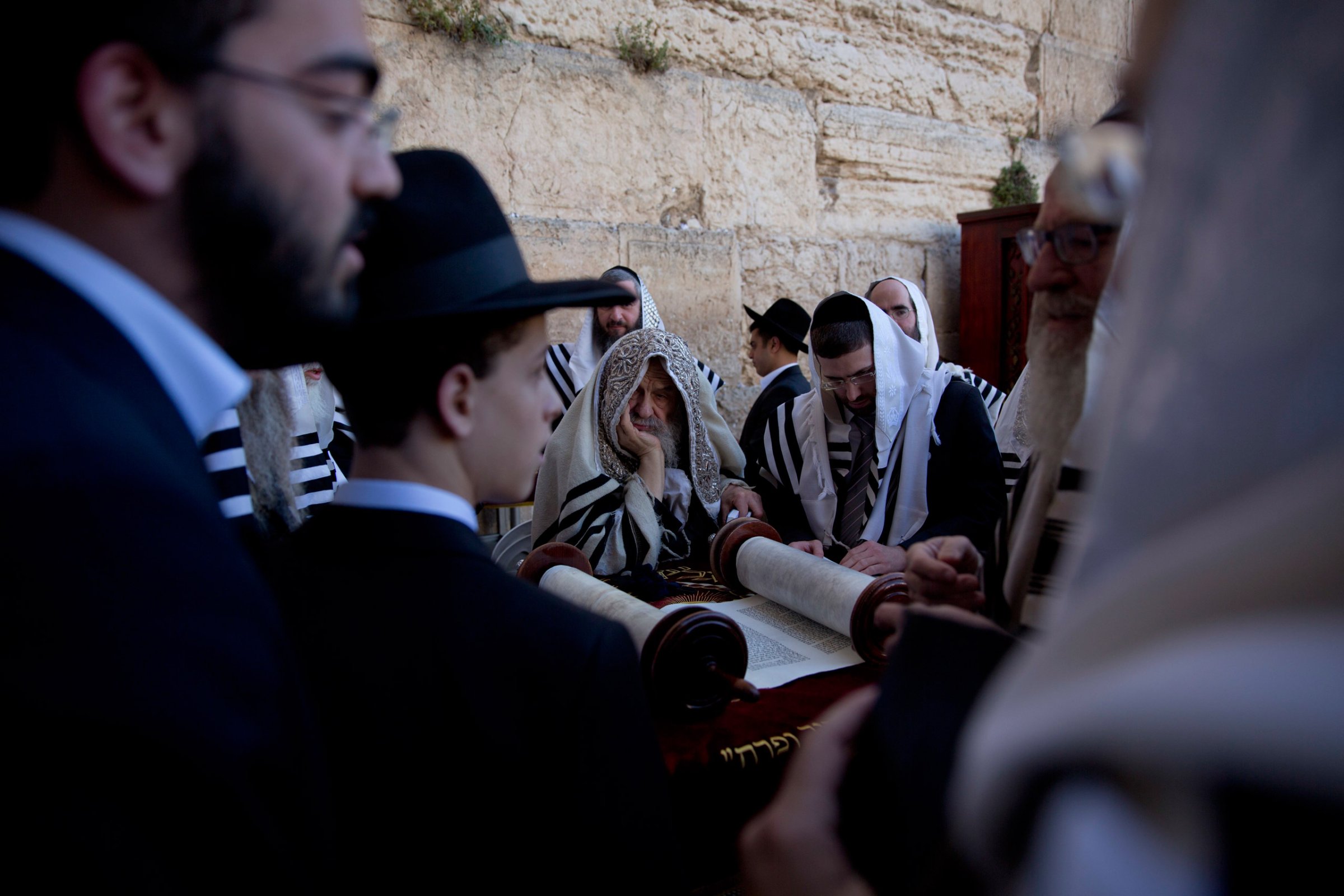Covered in prayer shawls, ultra-Orthodox Jewish men read from a Thora scroll during the Jewish holiday of Passover in front of the Western Wall, the holiest site where Jews can pray, in Jerusalem's Old City, Sunday, April 24, 2016. (AP Photo/Ariel Schalit)