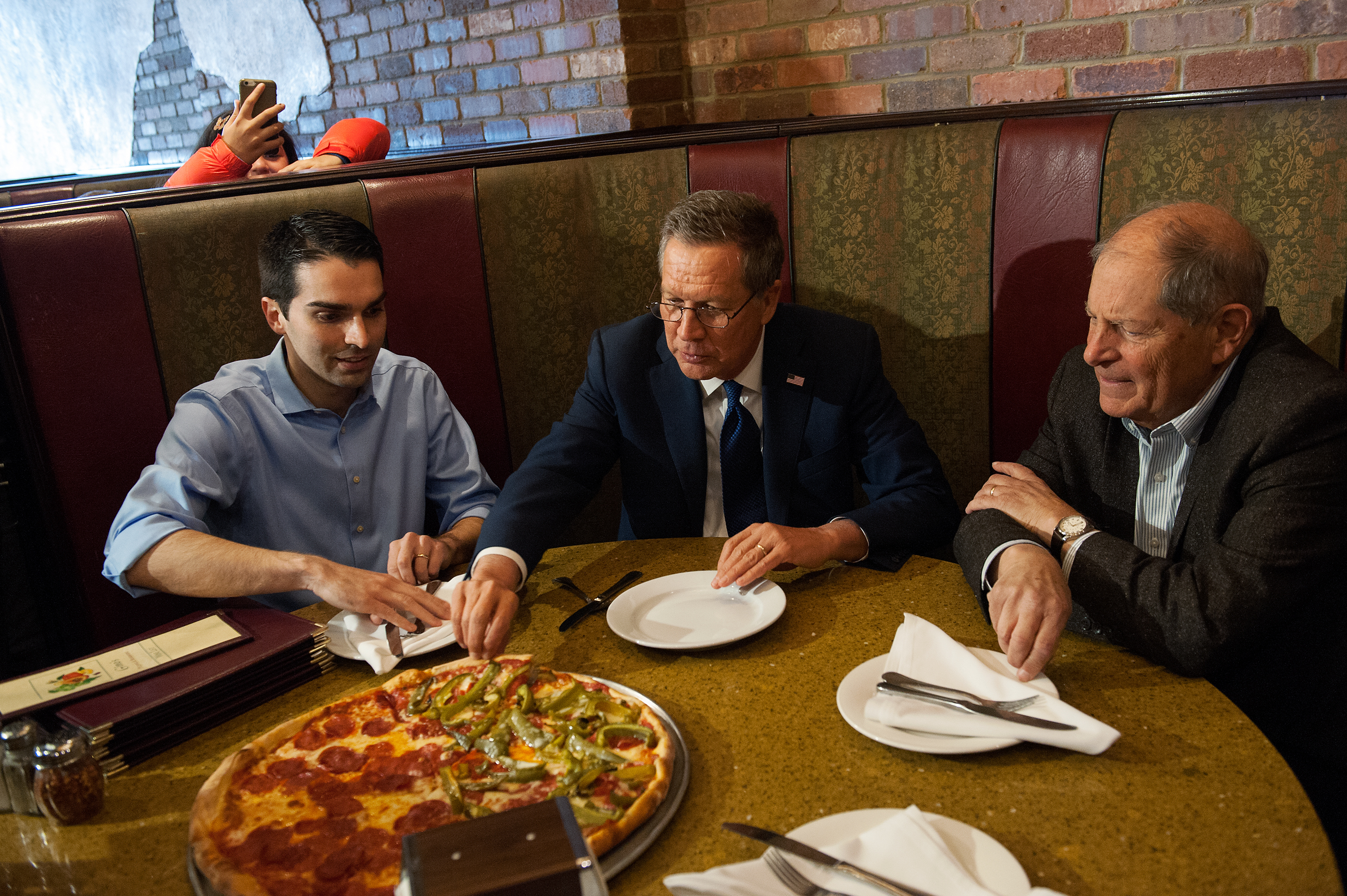 John Kasich and Bob Turner eat at Gino's Pizzeria and Restaurant in Queens, New York City on March 30, 2016. (Bryan Thomas—Getty Images)