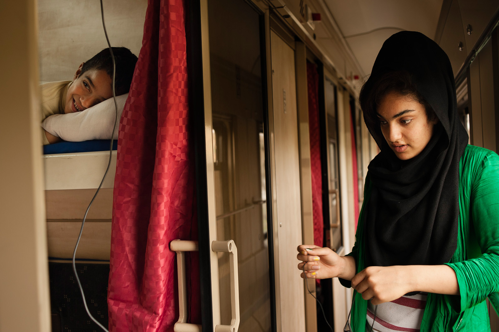 Mozhdeh, 15, and her eight year old brother spend time in their cabin on the TransAsia train that goes from Tehran to Ankara. They are both equally saddened and confused by their parents' decision to flee the country and become refugees in Turkey. Eastern Azerbaijan, Iran, April 4, 2013.