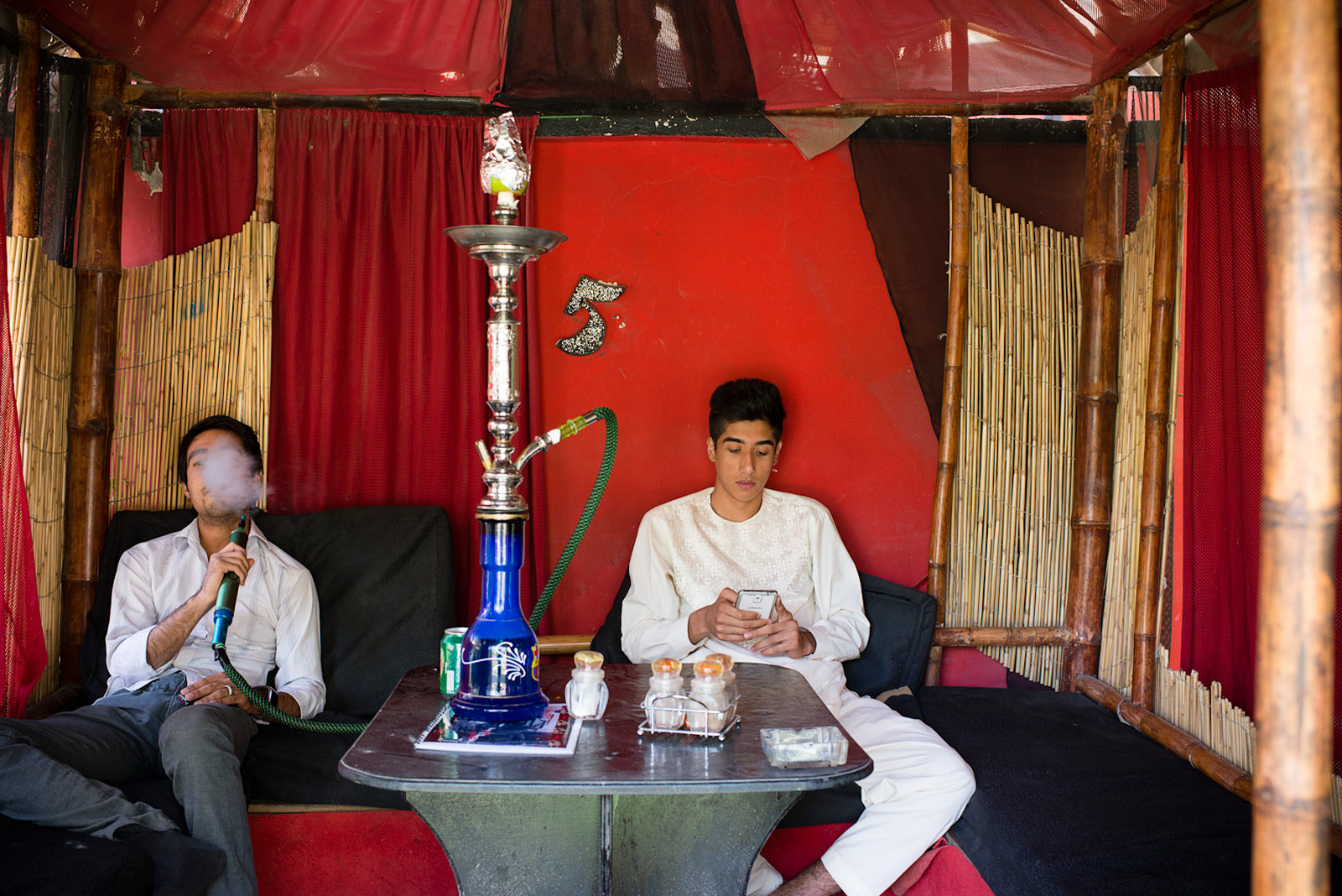 Young Afghan men, all in their early 20s, socialize and smoke hooka at Cafe Che, in Western Kabul. Cafe Che is one of the fewer cafes that have become very popular among young people in mixed groups as a meeting place. Kabul, Afghanistan, Aug. 10, 2014.