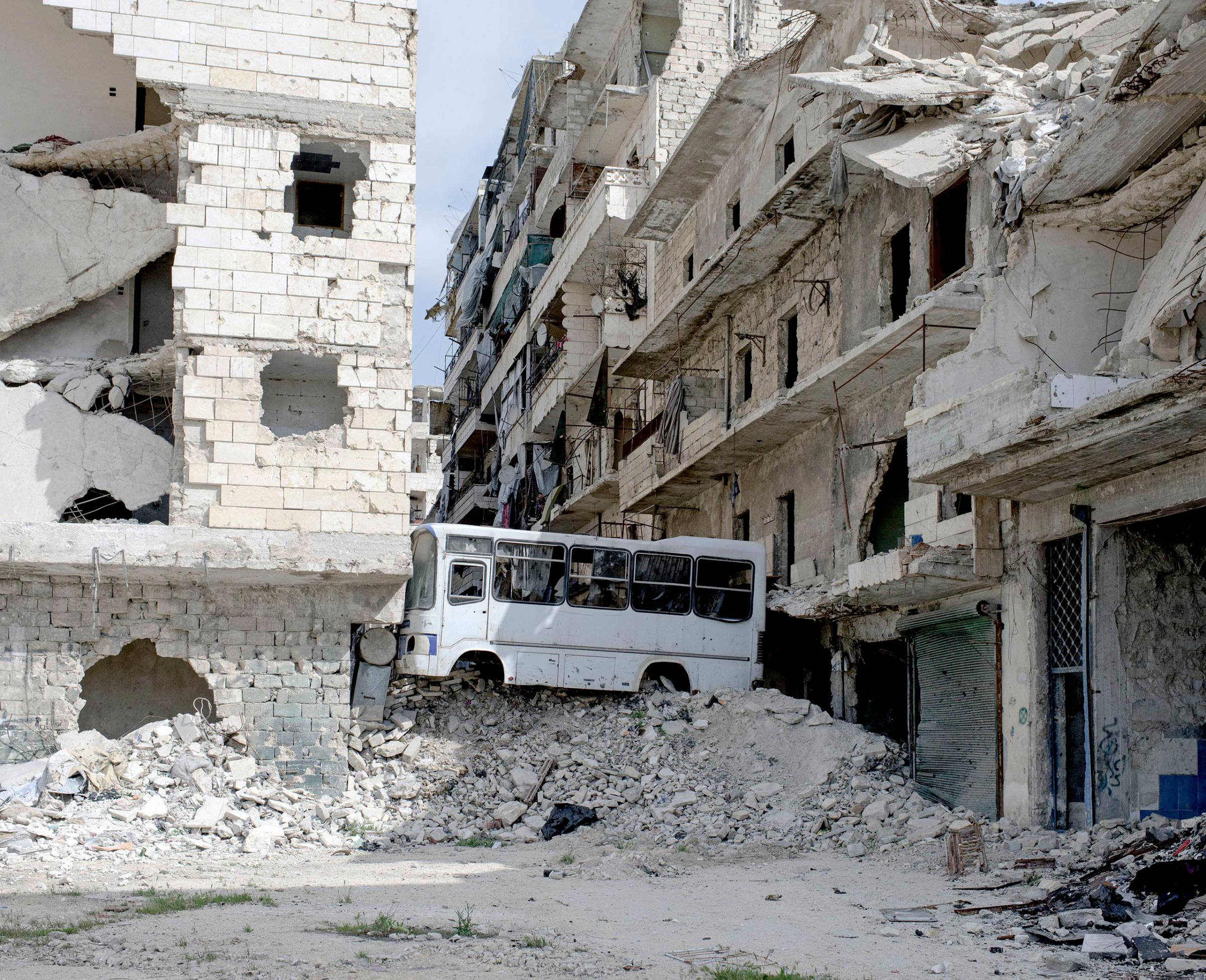 In the Salaheddin district, which is only 50% under government control, streets are blocked off with rubble and a bus. Aleppo, Syria, March 2016.