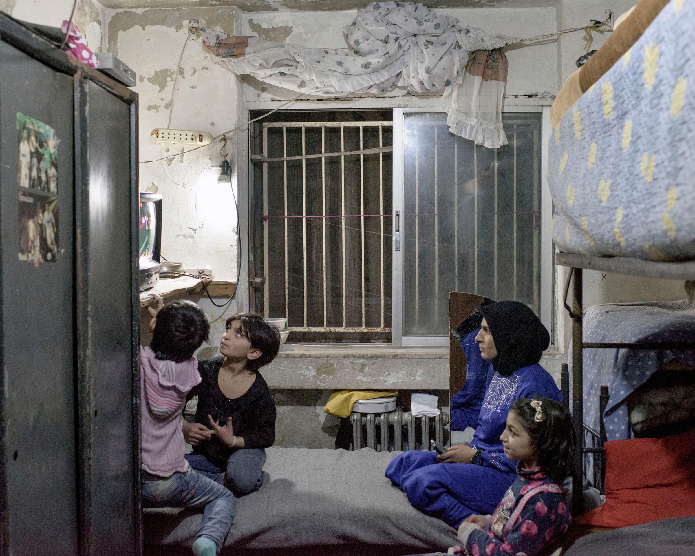 A family living in one room in a former university building, converted into housing for IDPs from surrounding districts, in Aleppo, Syria, March 2016.