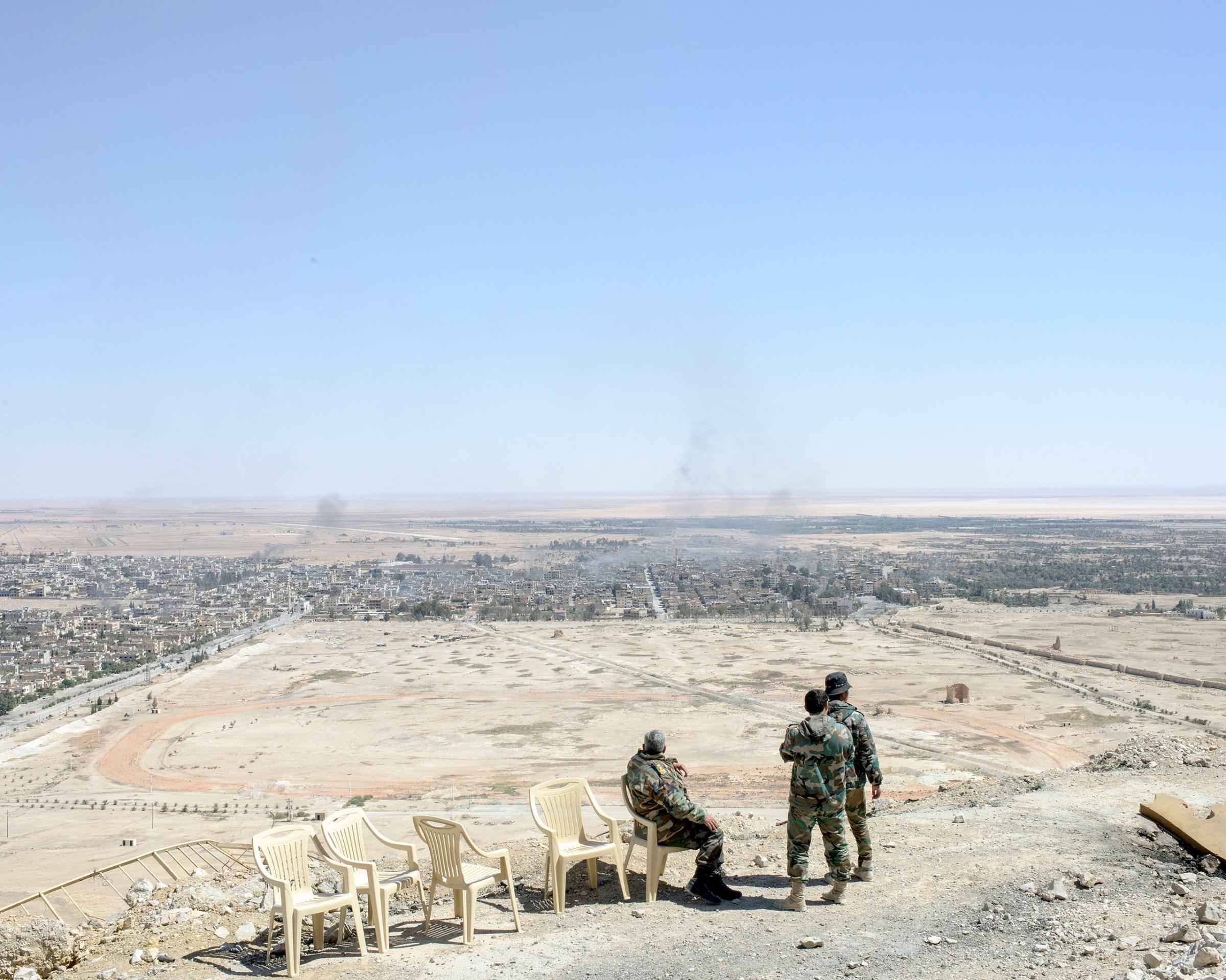 Syrian army generals and soldiers gaze over modern Palmyra from the medieval hilltop citadel, April 1, 2016.