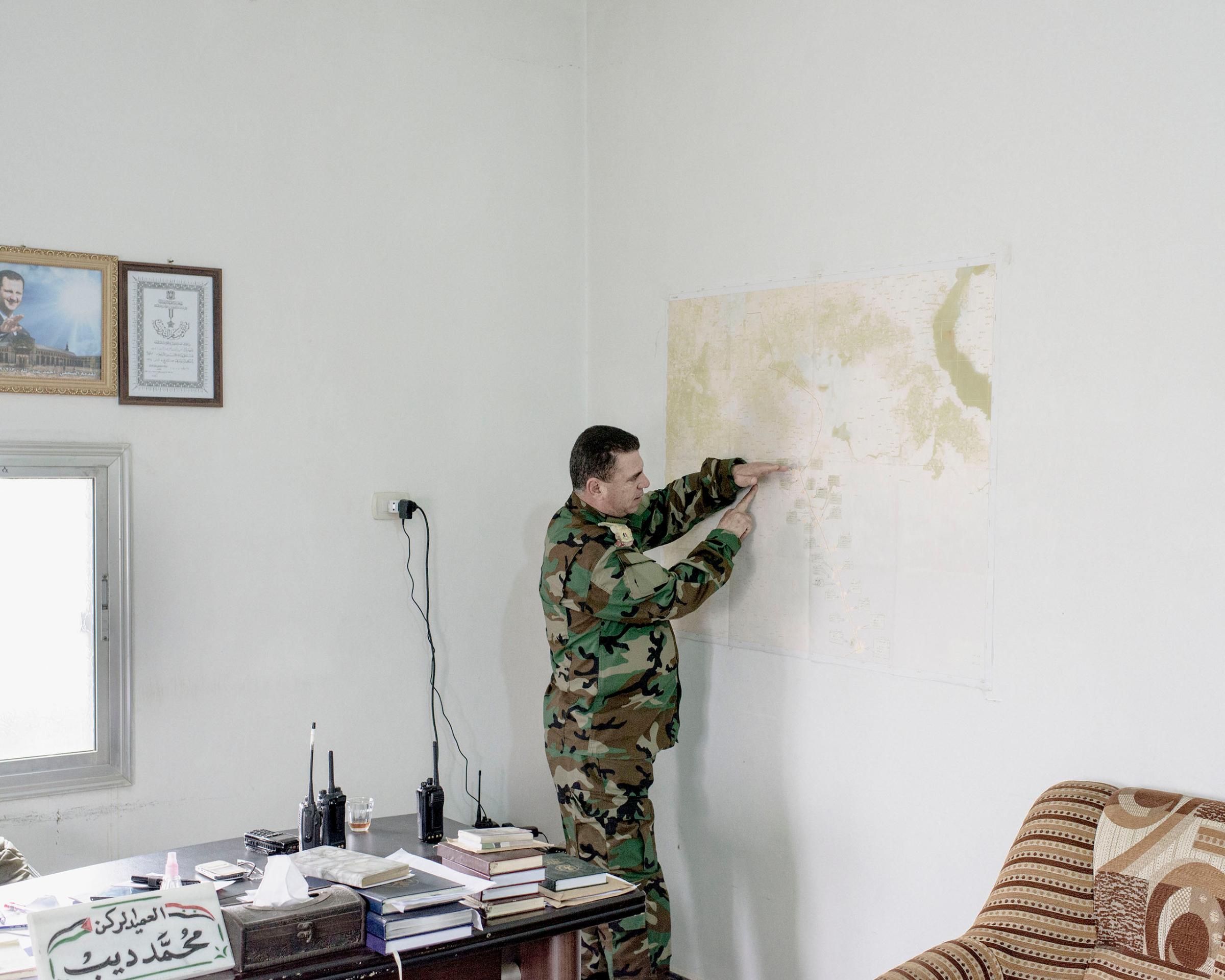 On the road between Homs and Aleppo, a Syrian army commander in charge of keeping the road to Aleppo open points out army and ISIS positions on a map of the area. March 2016.