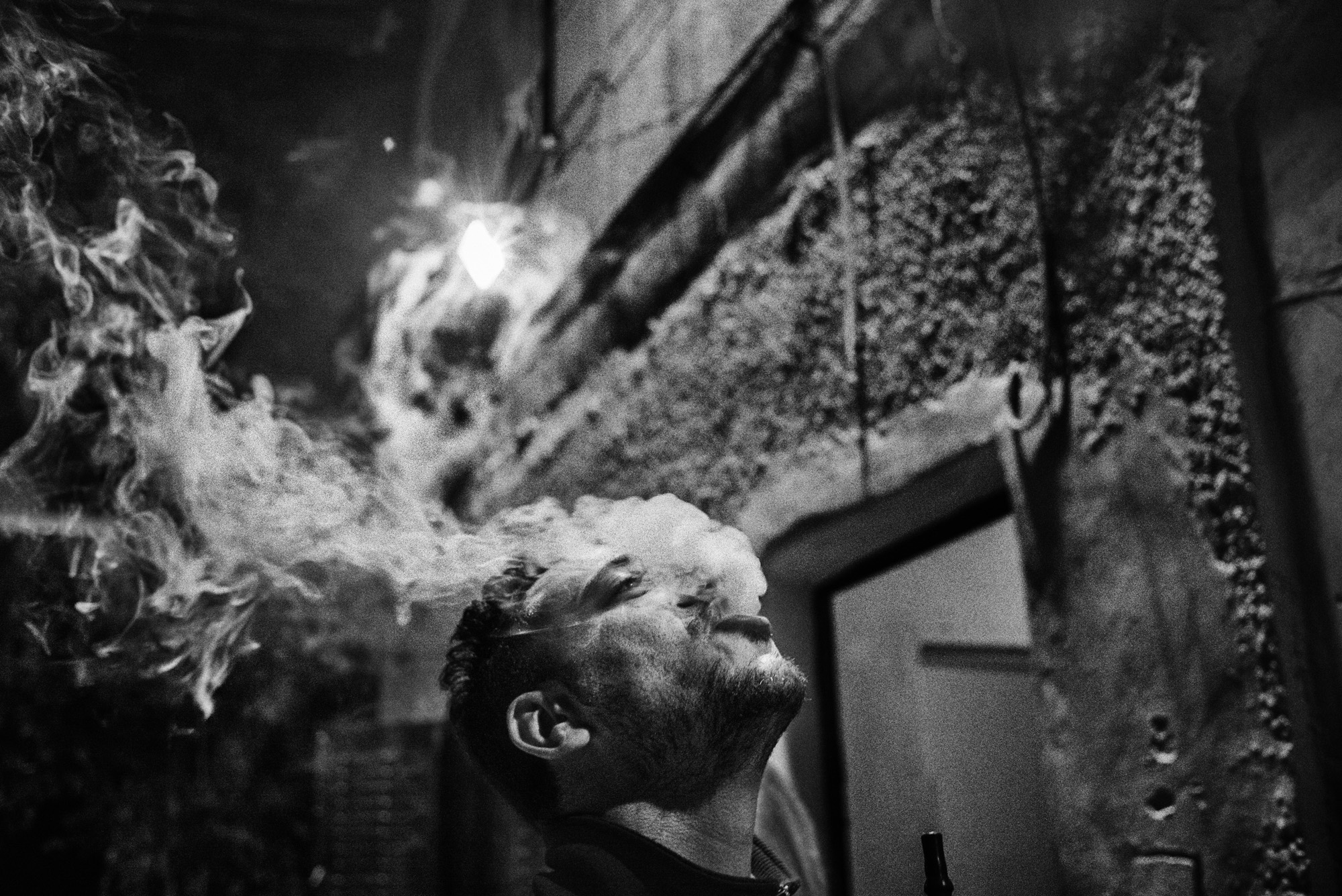Muhannad Qafesha smokes shisha outside the headquarters of Youth Against Settlements, a Palestinian activist organization located in the Tel Rumeida neighborhood of Hebron, November 2015.