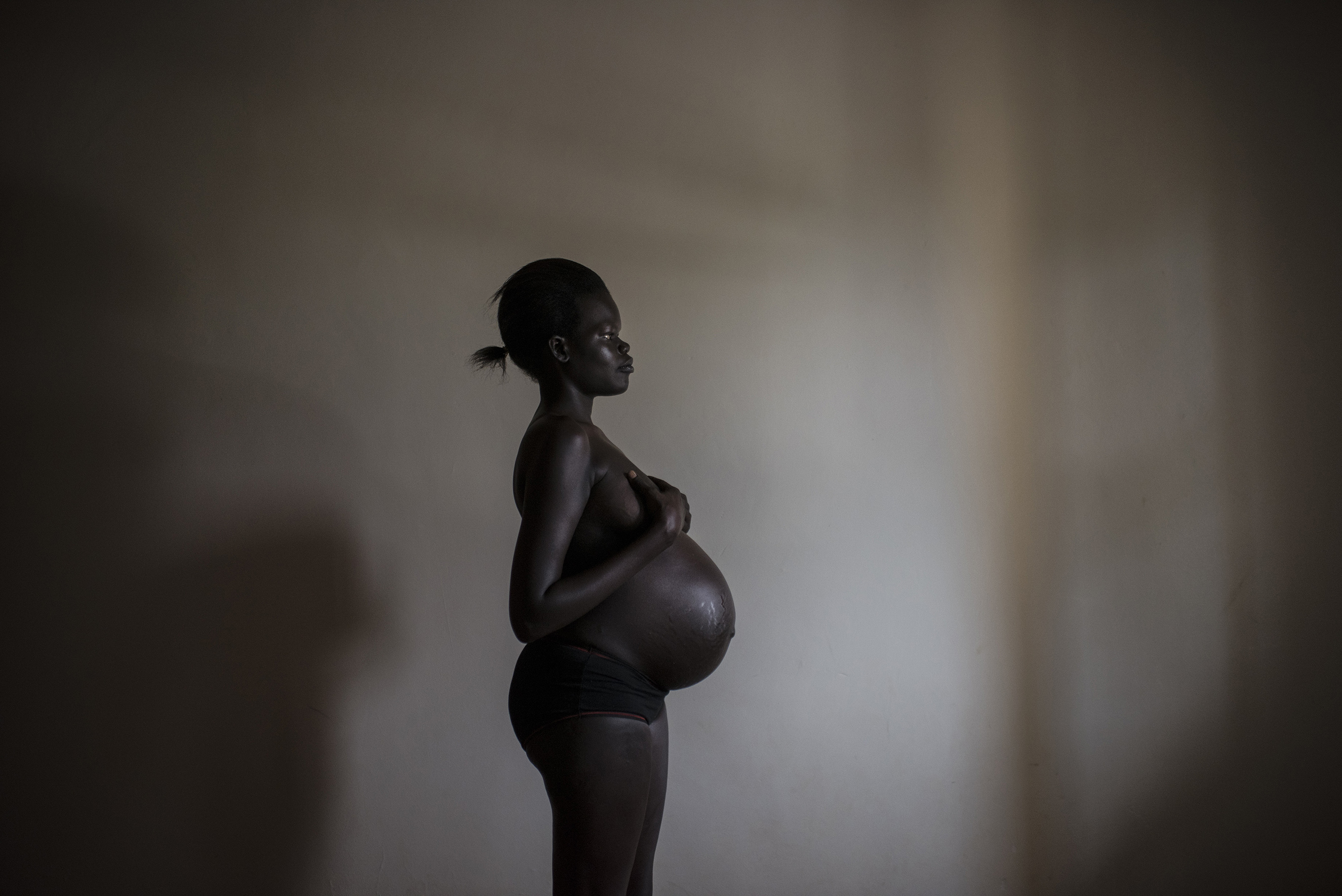Ayak poses while nine months pregnant at a safe house in Uganda, Dec. 8, 2015. She lost her entire family to a rebel attack on her village near Bentiu, in South Sudan. She was raped while fleeing, alone, for a U.N. camp, and then raped repeatedly while she was at the camp. One of her rapists gave her HIV. Ayak says that her unborn child is the only family she is likely to ever have.From  The Secret War Crime: How Do You Ask Women to Relive Their Worst Nightmares?
