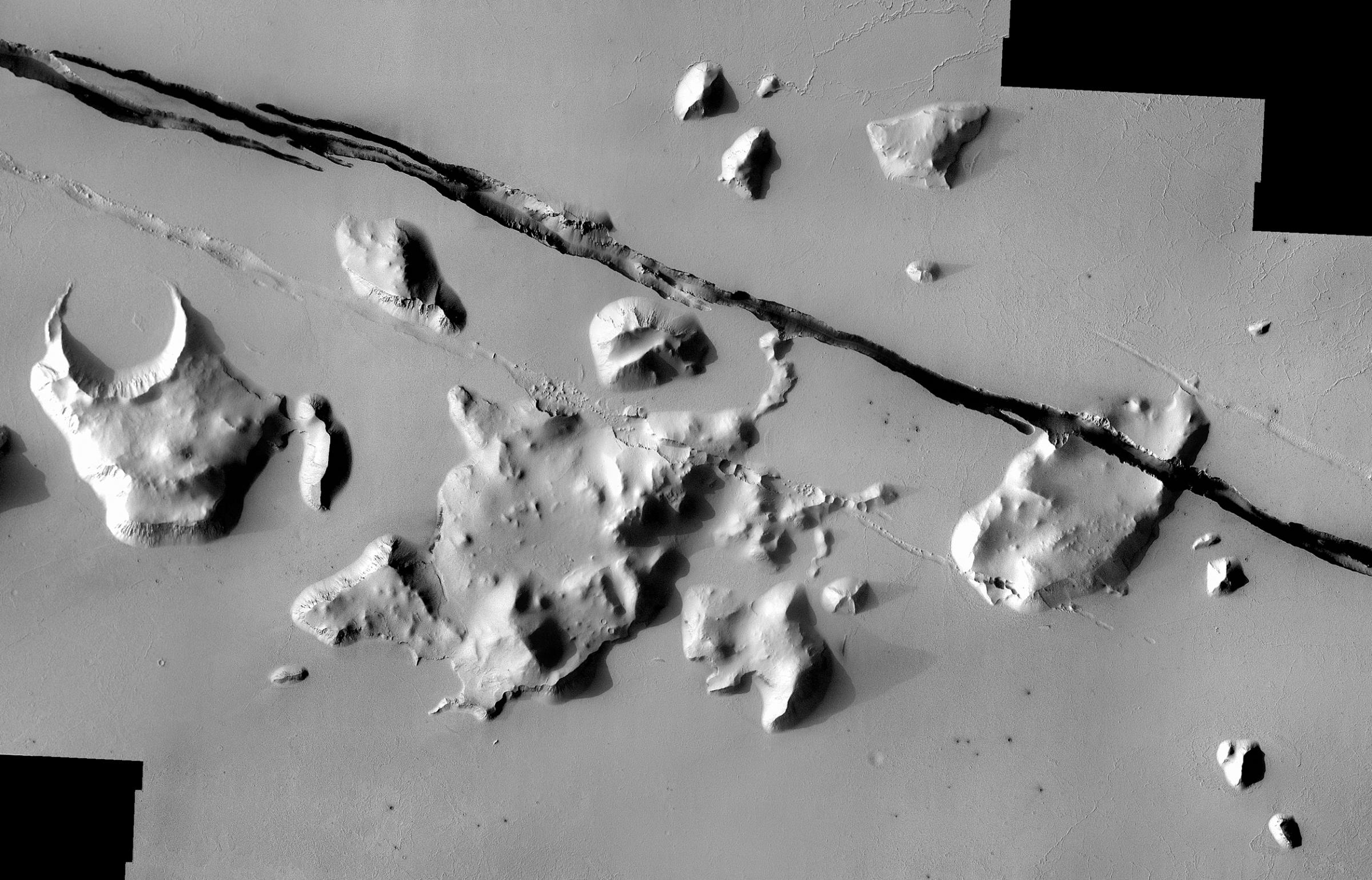 Geological faulting has opened cracks in the Cerberus region that slice through flat plains and mesas alike. This view covers an area 35 miles wide. It combines images taken during the period from May 2002 to July 2004 by the Thermal Emission Imaging System instrument on NASA's Mars Odyssey orbiter.