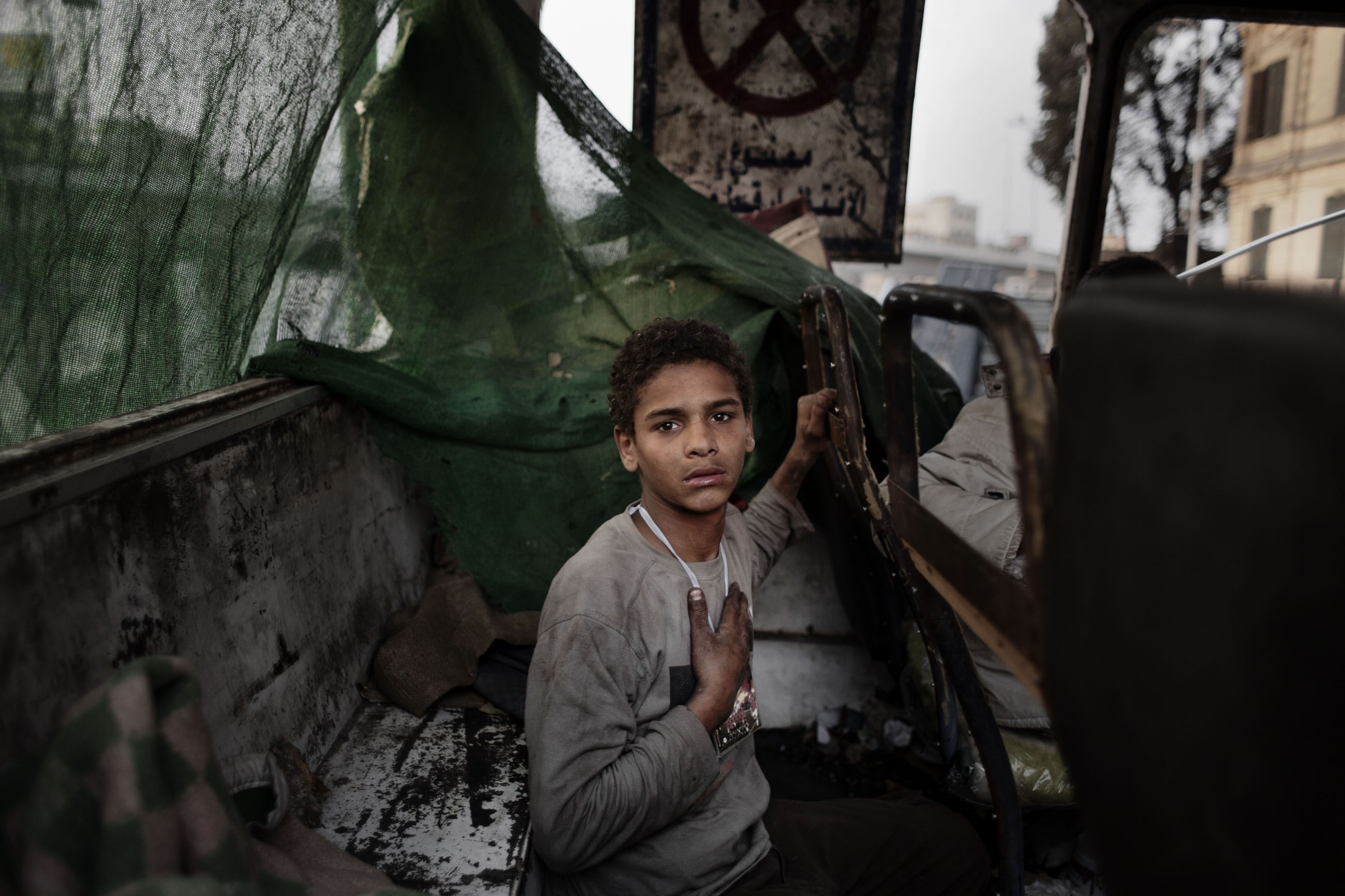 A young Egyptian protestor inside the shell of a burned out bus used as a barricade at the entrance to Tahrir Square, Cairo, Feb. 7, 2011.
