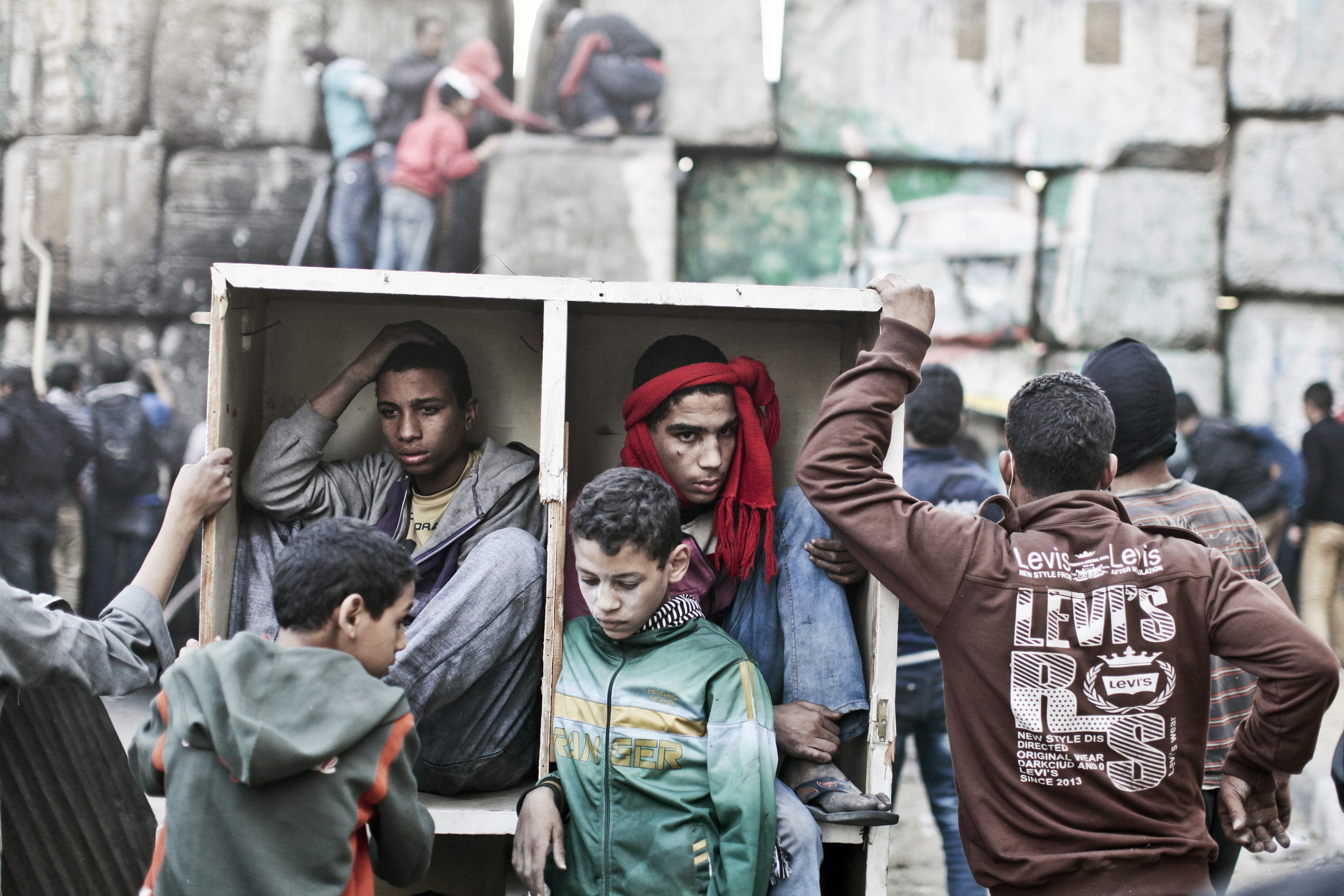 Young protestors take shelter behind a barricade during clashes with Egyptian police on the second anniversary of the Revolution. Cairo, Egypt, Jan. 2013.