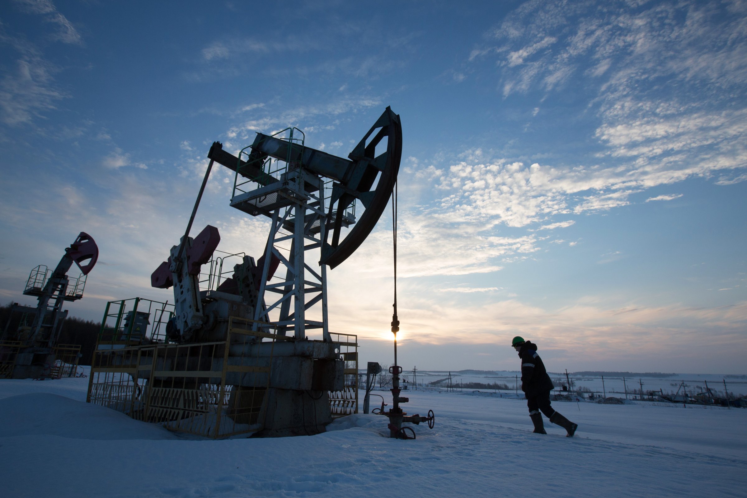 An oil worker inspects a pumping jack, also known as a 'nodding donkey,' during drilling operations in an oilfield operated by Bashneft PAO in the village of Otrada, 150kms from Ufa, Russia, on Saturday, March 5, 2016.