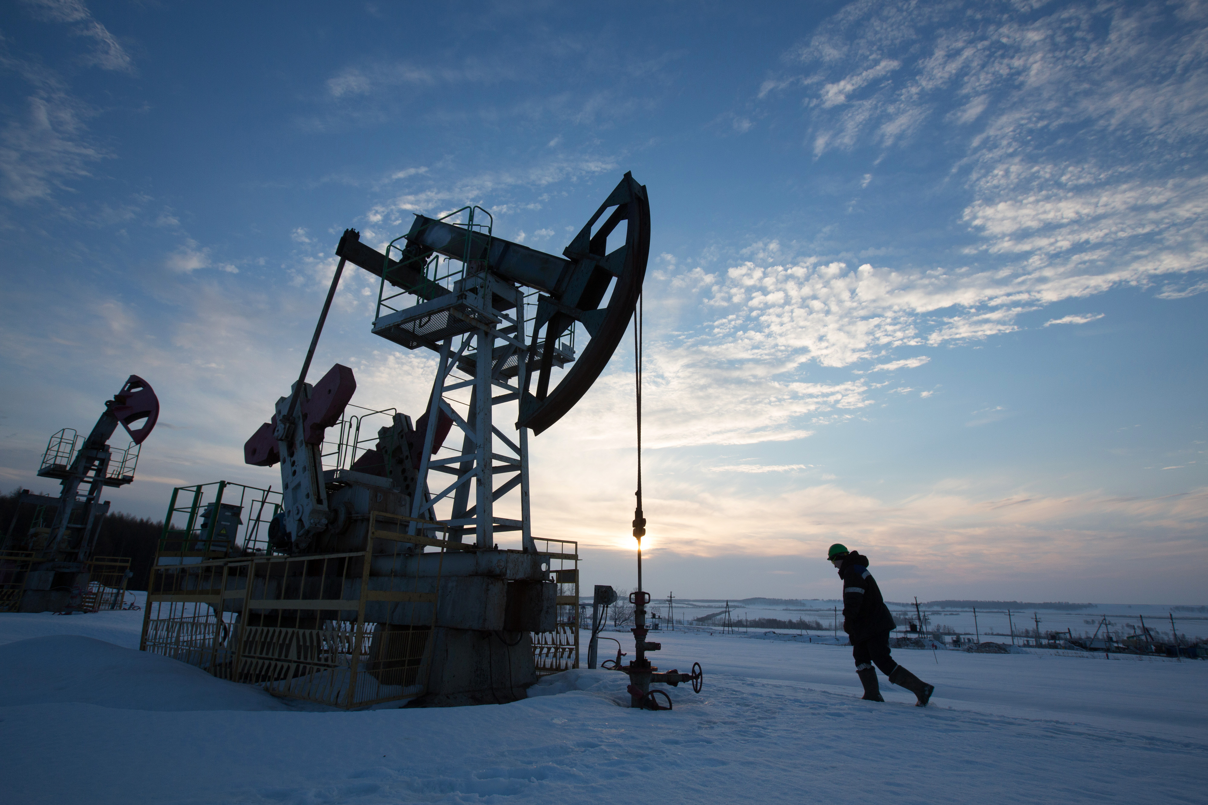 An oil worker inspects a pumping jack, also known as a 'nodding donkey,' during drilling operations in an oilfield operated by Bashneft PAO in the village of Otrada, 150kms from Ufa, Russia, on Saturday, March 5, 2016. (Andrey Rudakov—Bloomberg/Getty Images)