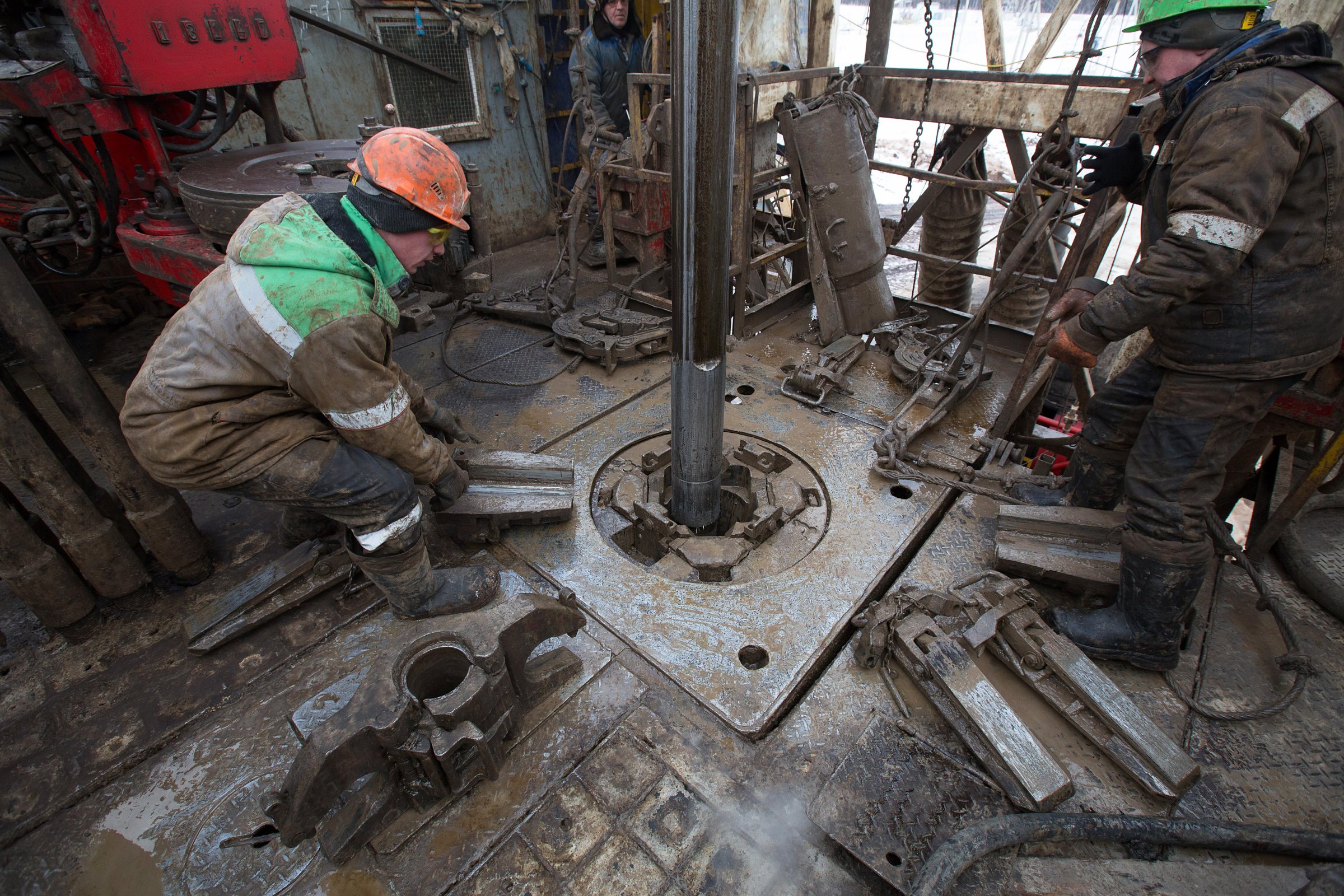 Oil workers adjust a pipe section at the turntable on an oil derrick during drilling operations by Targin JSC, a unit of Sistema JSFC, in an oilfield operated by Bashneft PAO in the village of Otrada, 150kms from Ufa, Russia, on Saturday, March 5, 2016.
