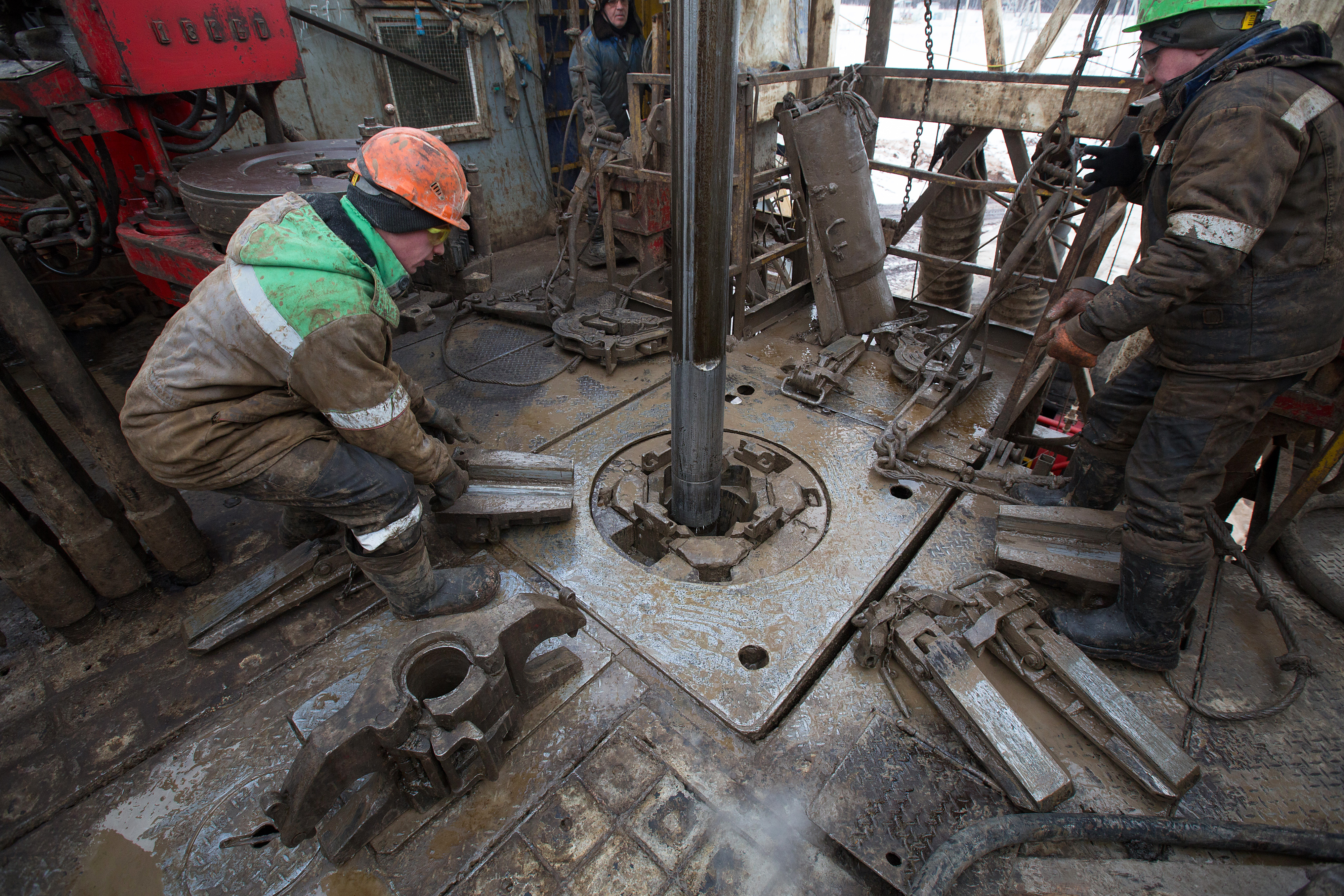 Oil workers adjust a pipe section at the turntable on an oil derrick during drilling operations by Targin JSC, a unit of Sistema JSFC, in an oilfield operated by Bashneft PAO in the village of Otrada, 150kms from Ufa, Russia, on Saturday, March 5, 2016. (Andrey Rudakov—Bloomberg/Getty Images)