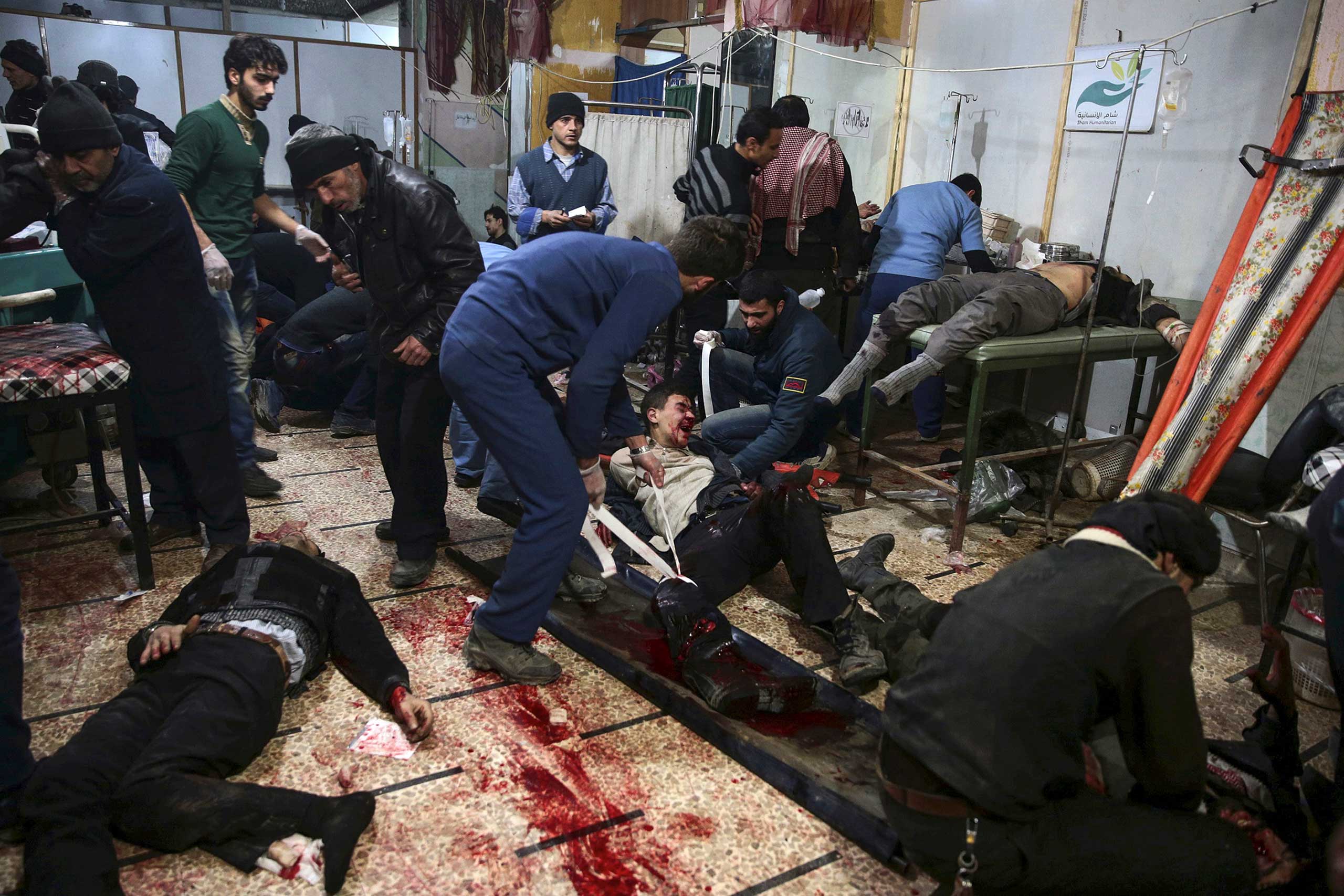 Medics treat injured people inside a field hospital after what activists said were air and missile strikes in the Douma neighborhood of Damascus, Syria, Dec. 13, 2015.