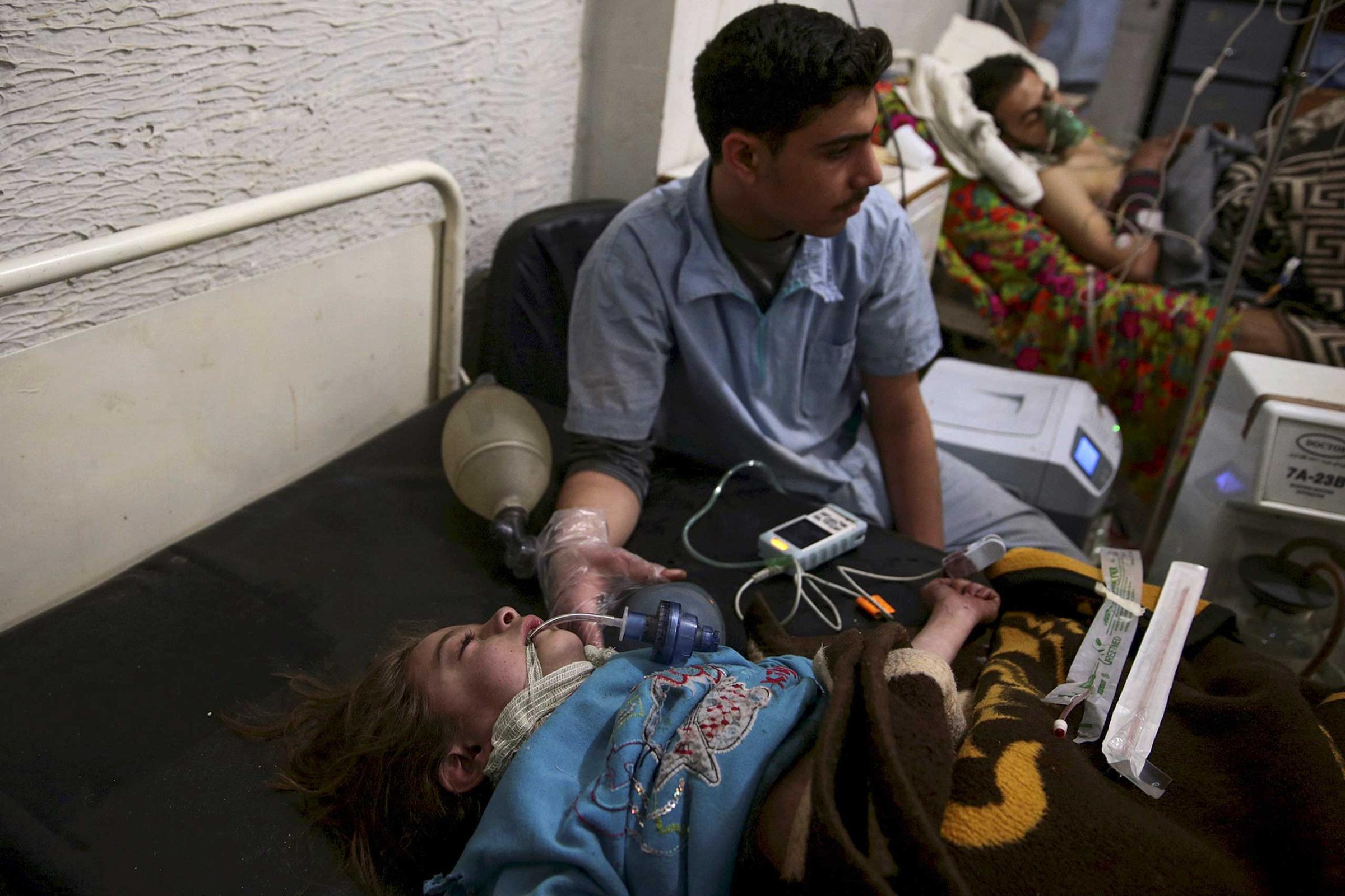 A medic treats an injured girl inside a field hospital after what activists said were air and missile strikes in the Douma neighborhood of Damascus, Syria December 13, 2015.