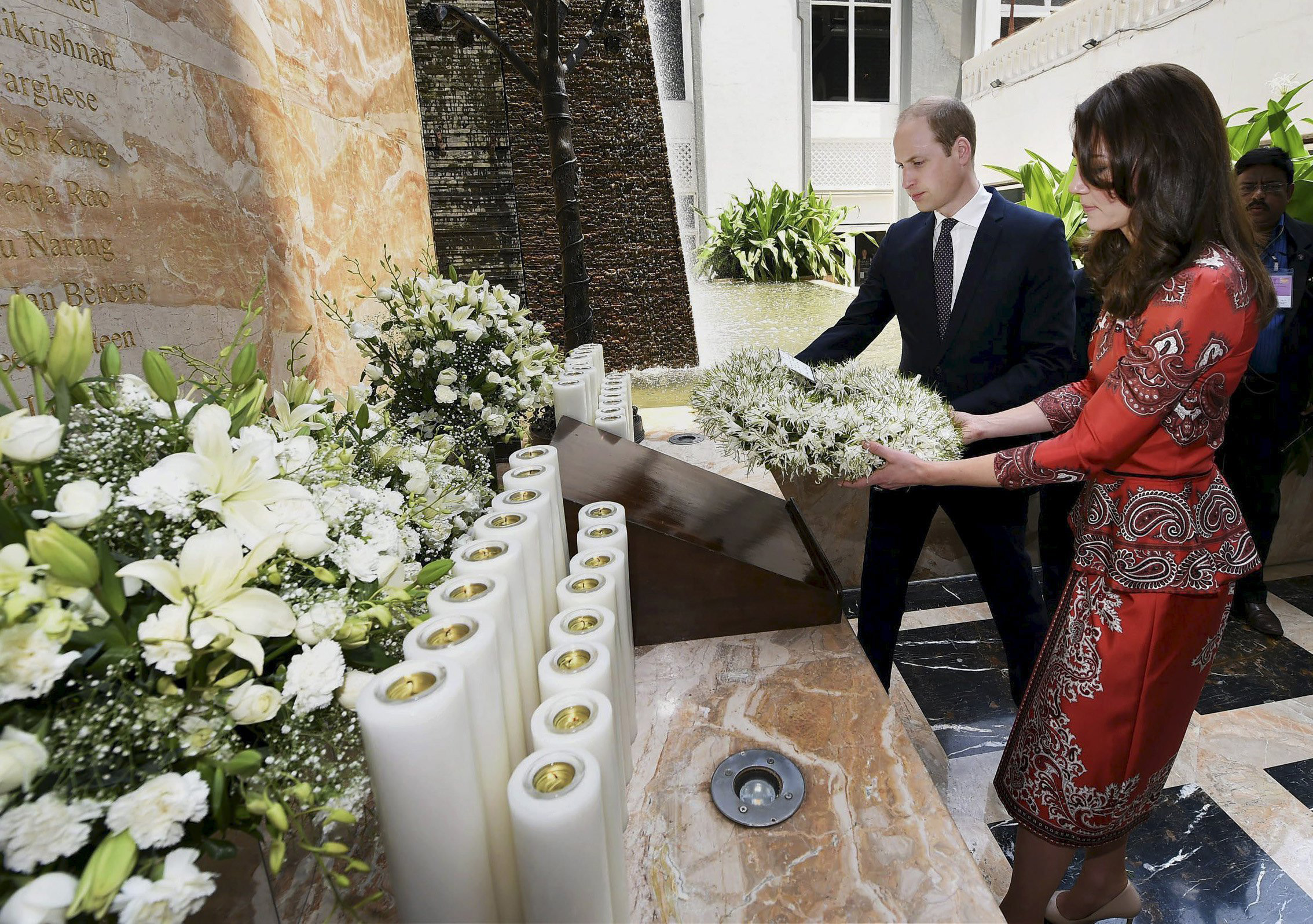 Prince William and Catherine hold a wreath as they pay their respects at the 26/11 memorial at the Taj Mahal Palace hotel, one of the sites of the 2008 attacks, in Mumbai, India, on April 10, 2016.