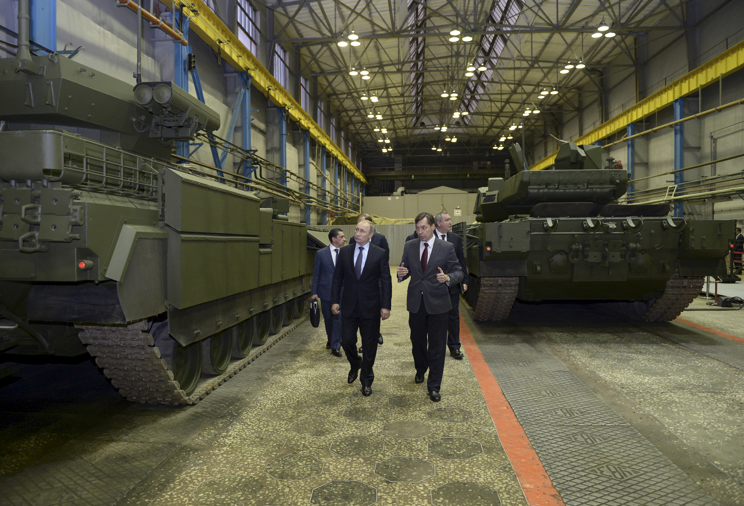 Russian President Vladimir Putin and Andrei Terlikov, the head of the Ural Transport Machine Building Design Bureau, walk by a Russian infantry fighting vehicle and a battle tank at the Uralvagonzavod factory in Nizhny Tagil, Russia, on Nov. 25, 2015. (Alexei Nikolskyi—Reuters)