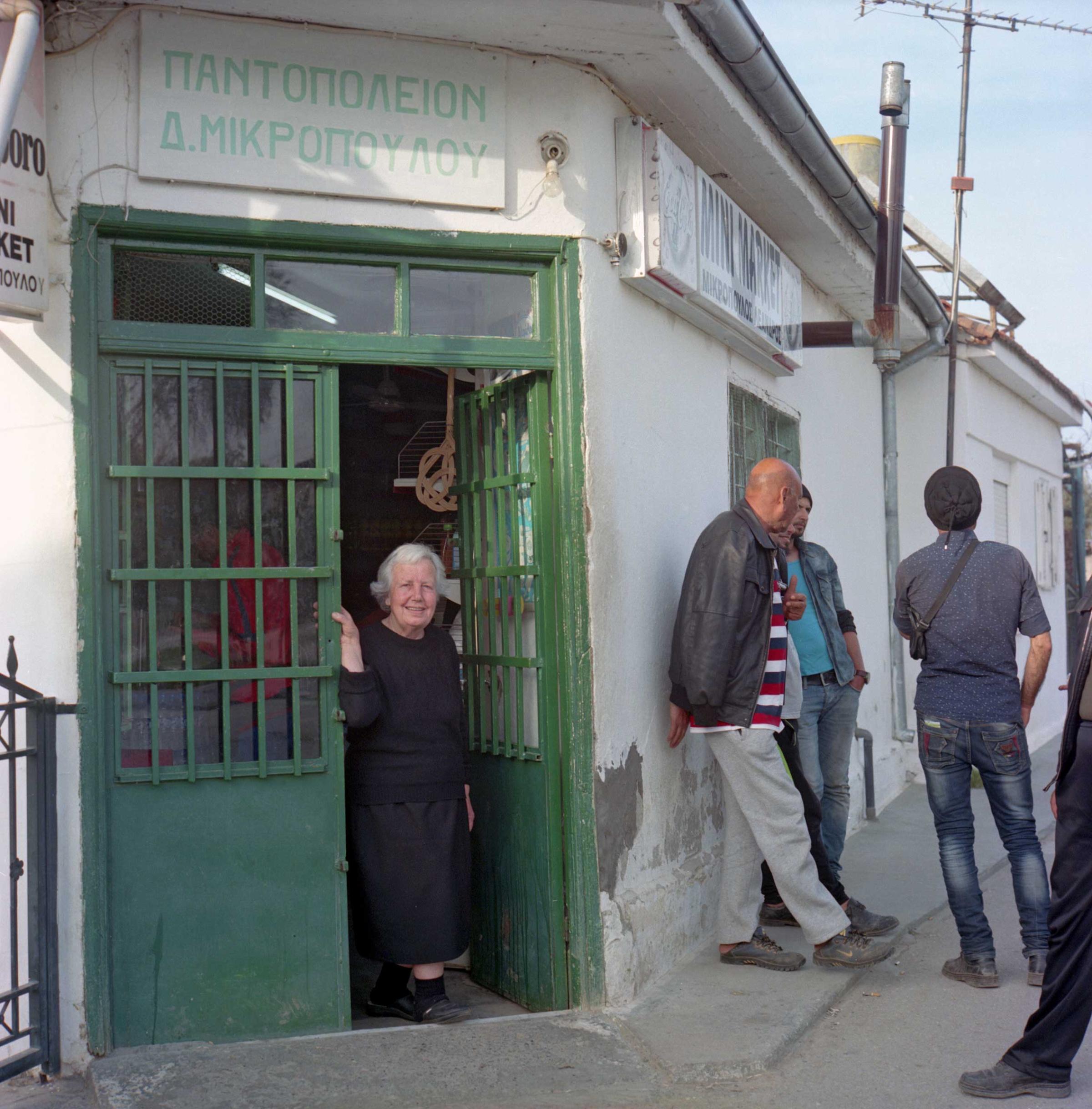 Antonia Mikropolou, 74 y.o. an elderly shopkeeper in Idomeni is cordial with the refugees that come to buy snacks, drinks and cigarettes. Since the inflow of reguees, this small convenience store has been turning much higher profits than before. Idomeni, a small town on the border with Macedonia with a population of only 120 original residents, now hosts more than 10,000 refugees who set up an informal camp here. Idomeni, Greece. April 2016