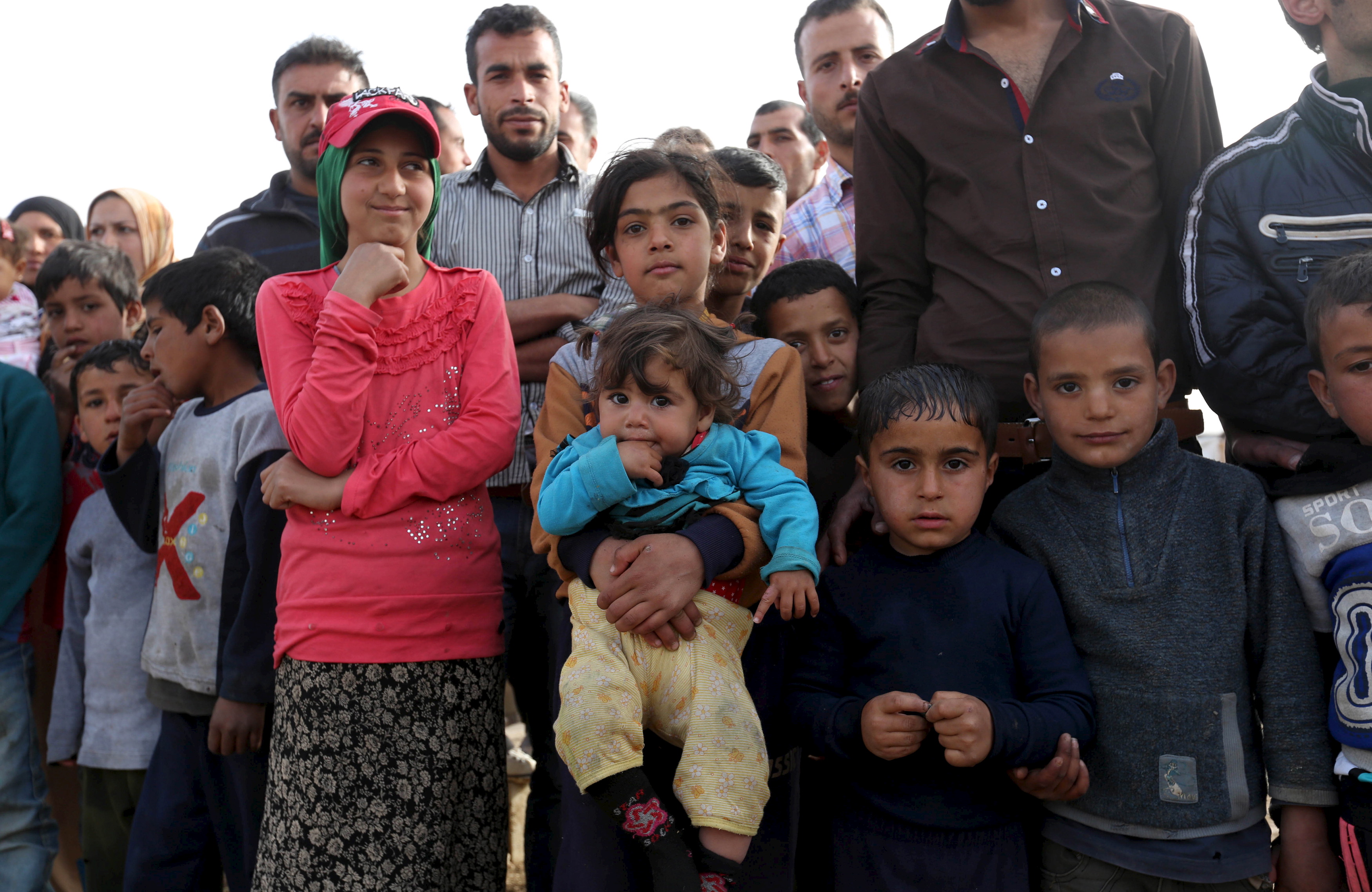 Syrian refugees stand as they gather during the visit of United Nations Secretary-General Ban to al-Dalhamiyeh camp in the Bekaa Valley