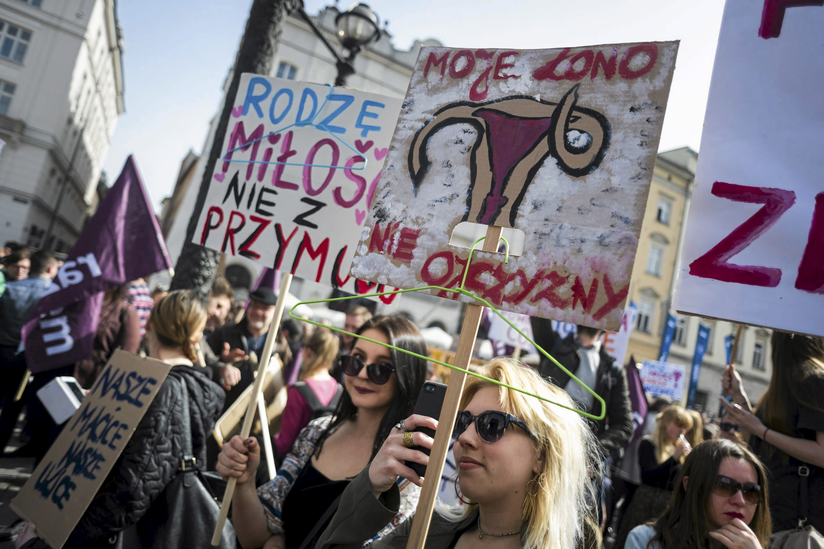Demonstrators in Krakow, Poland, hold signs reading: 