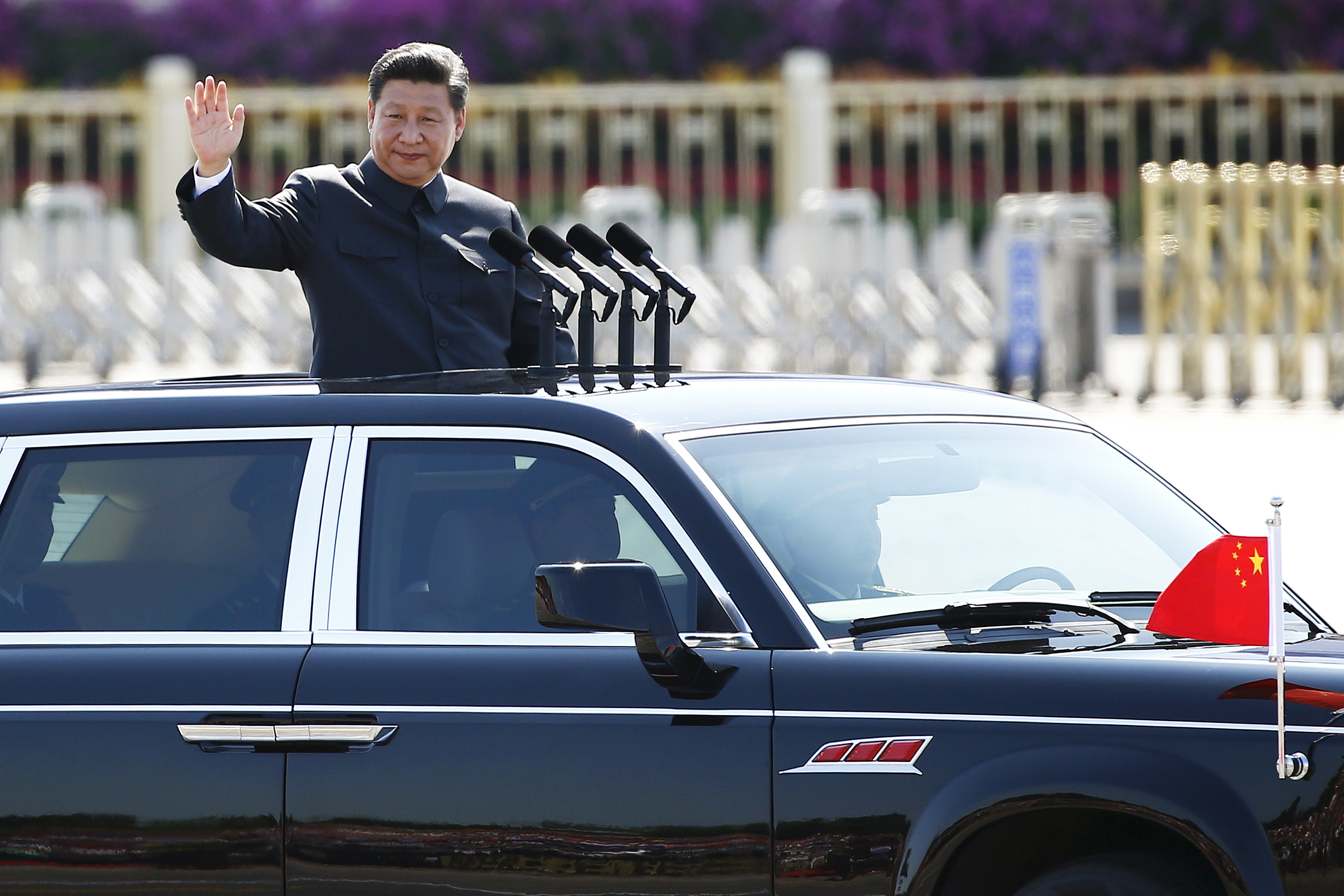 Chinese President Xi Jinping waves as he reviews the army, at the beginning of the military parade marking the 70th anniversary of the end of World War Two, in Beijing