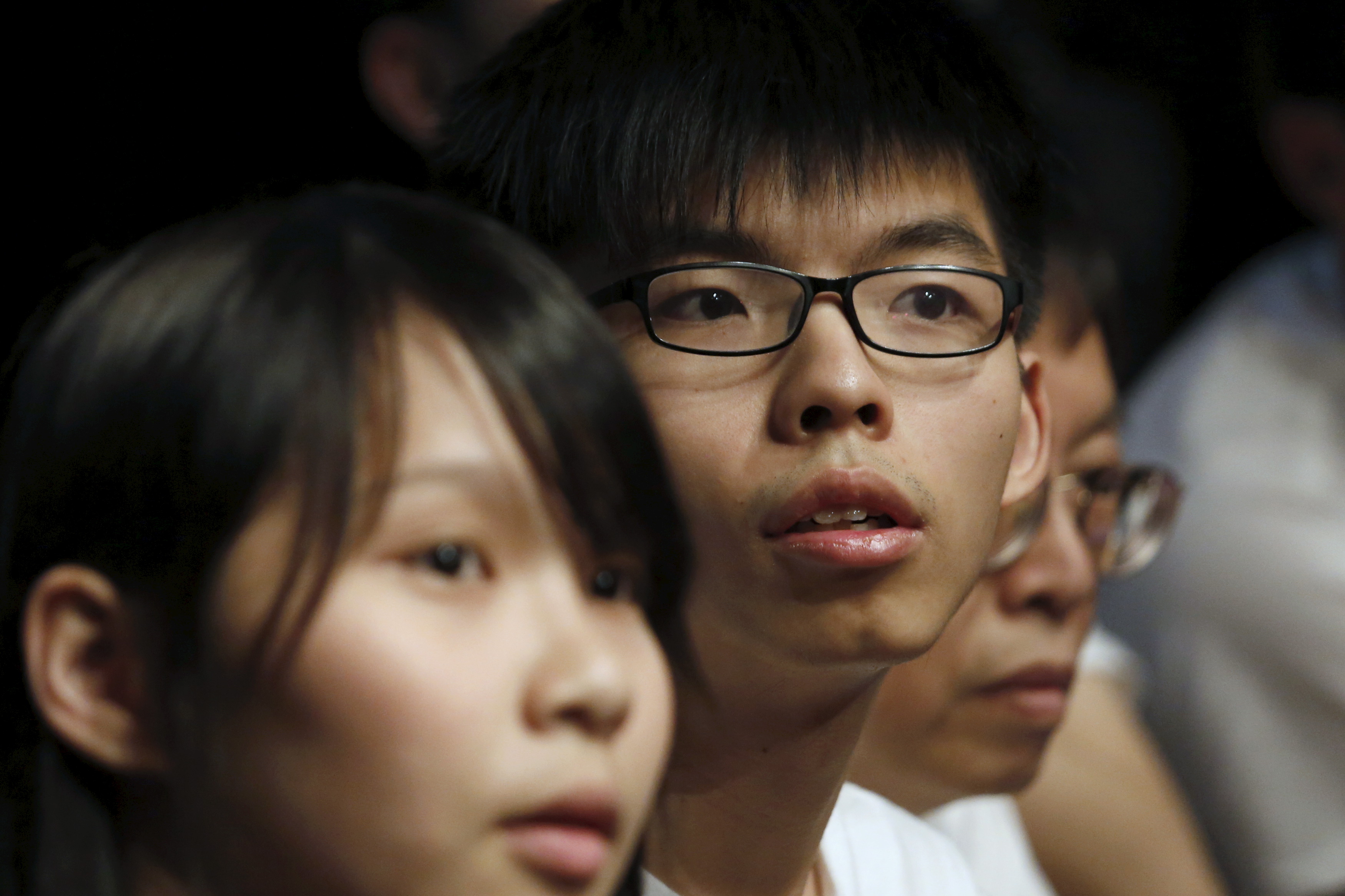 Student leaders of Occupy Central movement Joshua Wong, center, and Agnes Chow, left, attend the launching ceremony of their new political party Demosistō in Hong Kong on April 10, 2016 (Bobby Yip—Reuters)