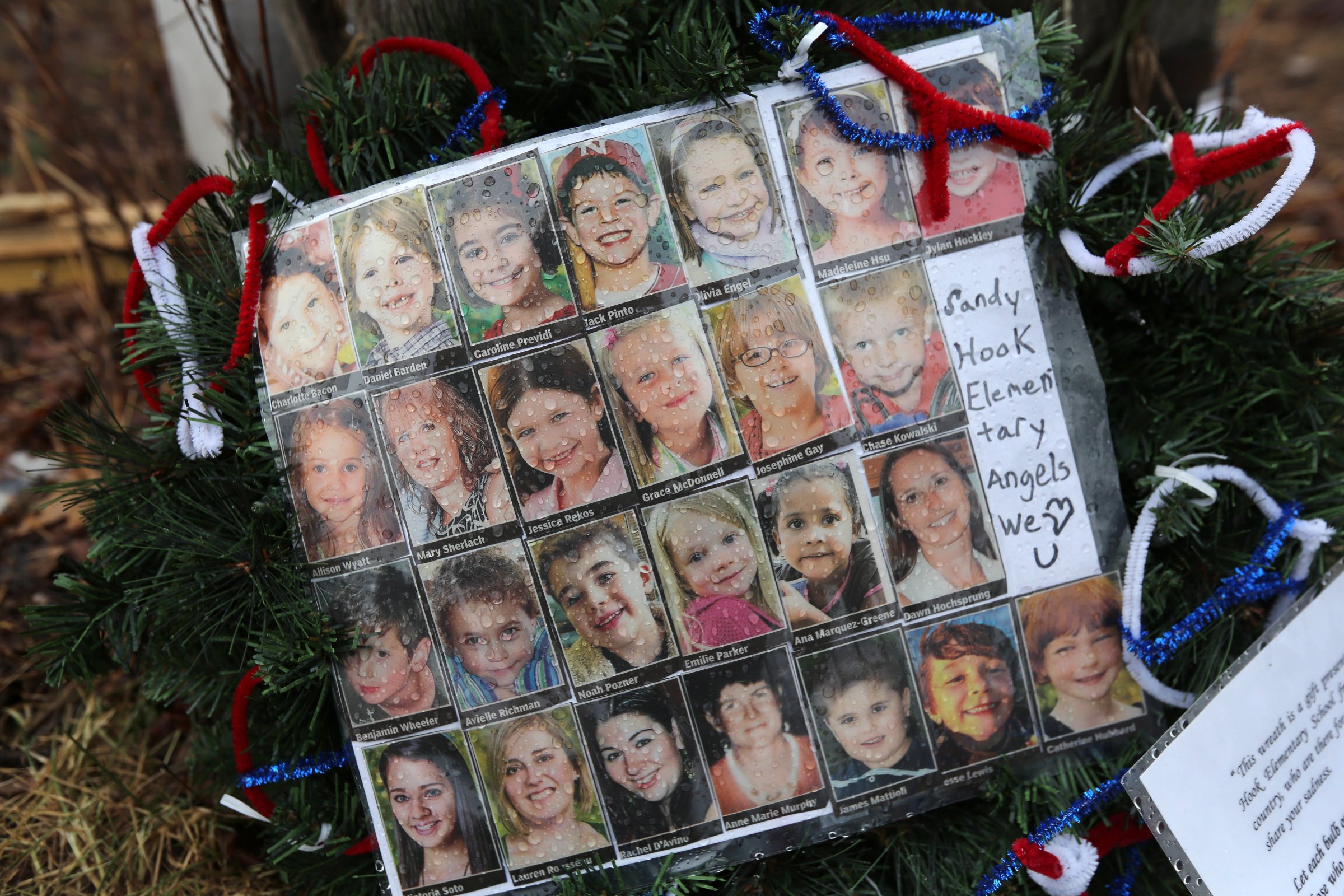 NEWTOWN, CT - JANUARY 14:  Photos of Sandy Hook Elementary School massacre victims sits at a small memorial near the school on January 14, 2013 in Newtown, Connecticut. The town marked a month anniversay since the massacre of 26 children and adults at the school, the second-worst such shooting in U.S. history.  (Photo by John Moore/Getty Images)