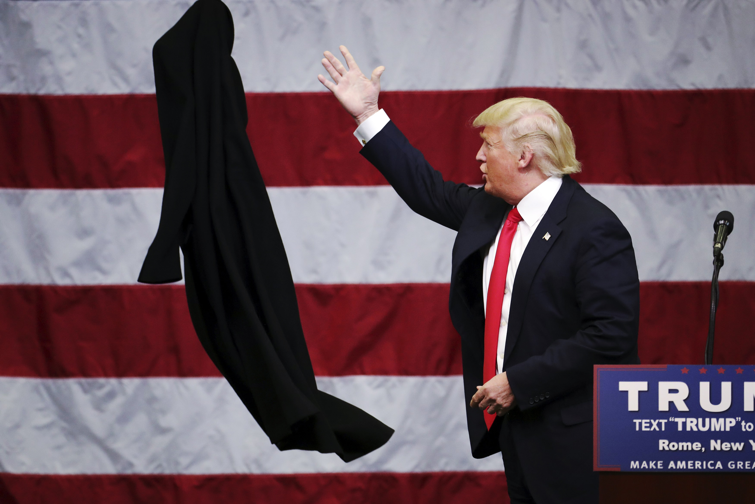 Republican presidential candidate Donald Trump tosses off his overcoat during a campaign event in Rome, N.Y. on April 12, 2016.