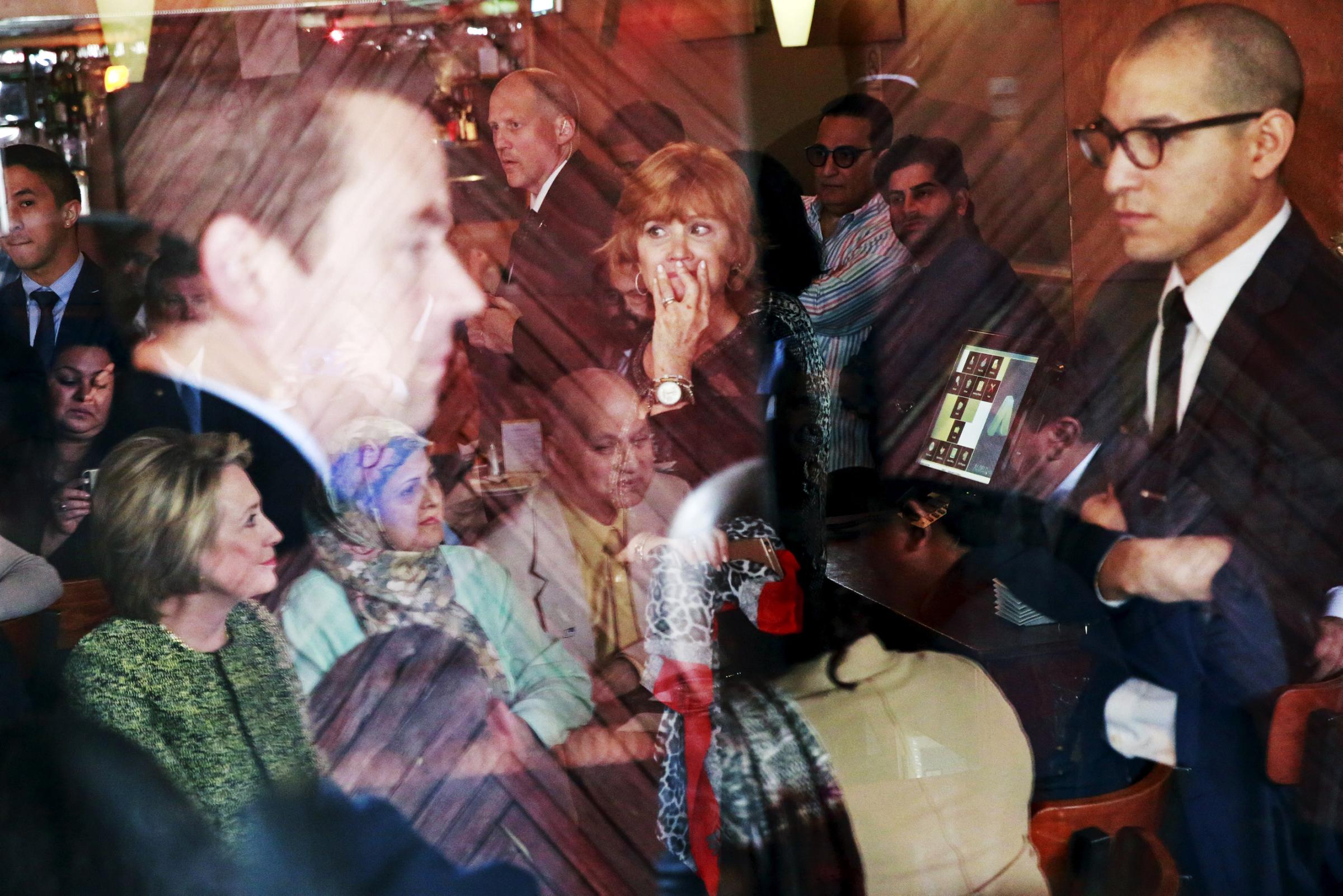 Patrons, security personnel, and members of the community gather to listen to Democratic presidential candidate Hillary Clinton during a visit to the Jackson Diner in New York's Queens borough on April 11, 2016.
