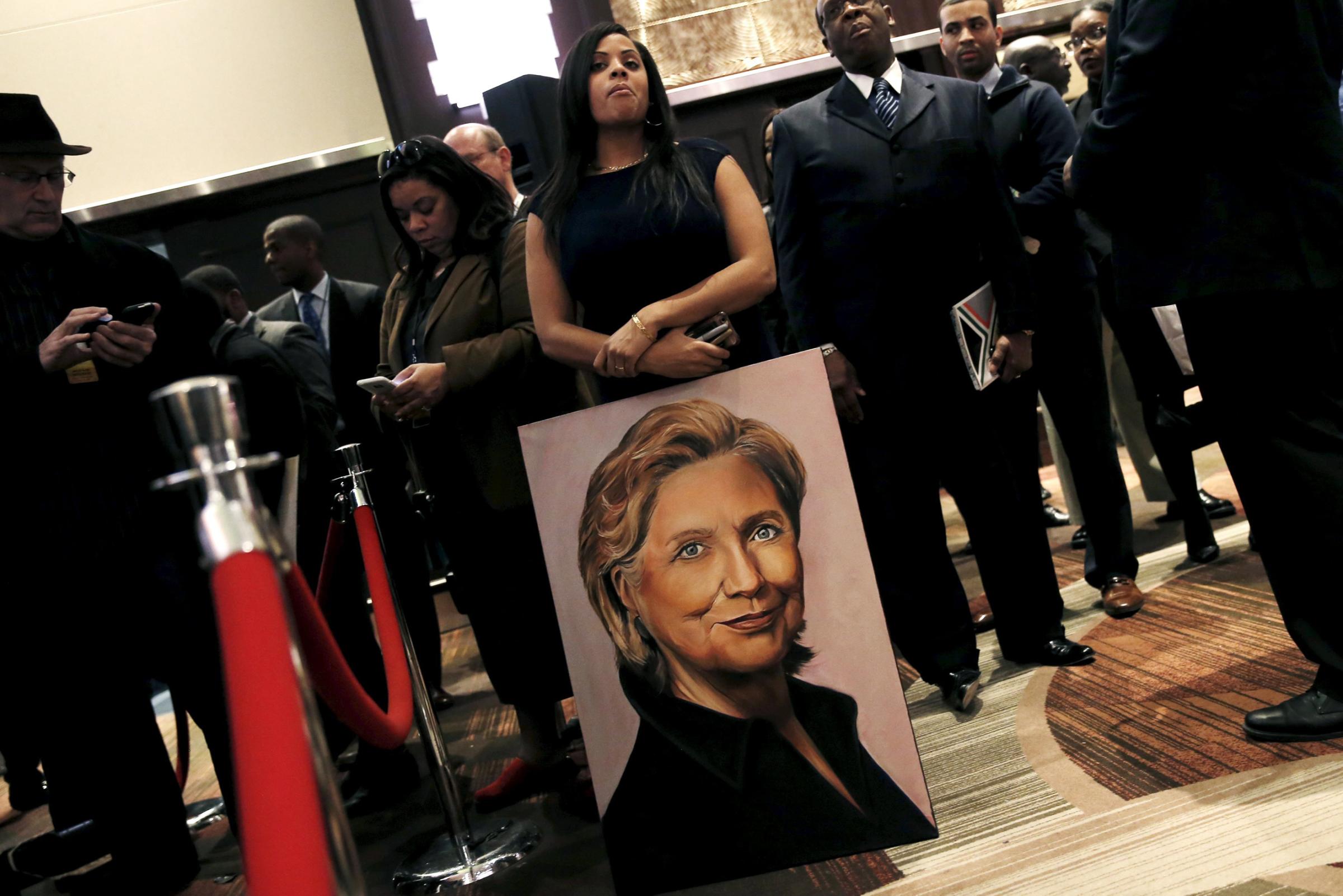 A supporter of Hillary Clinton stands with a painting at the National Action Network's 25th Annual Convention in New York on April 13, 2016.