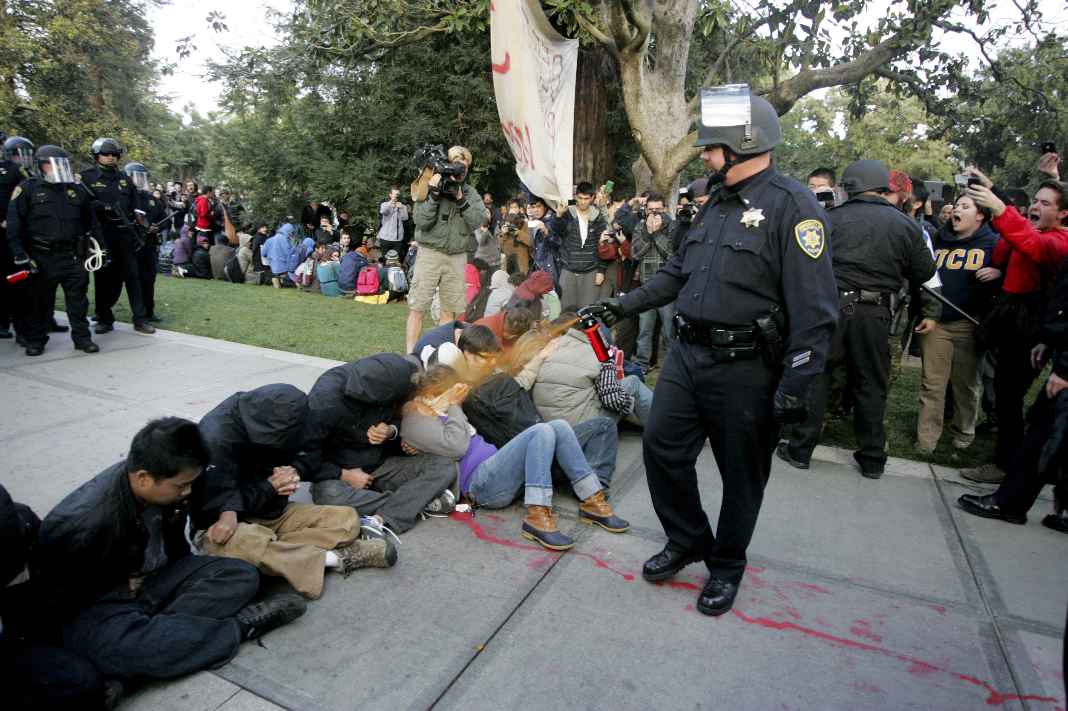 A University of California Davis police officer pepper-sprays students during their sit-in at an "Occupy UCD" demonstration in Davis, Calif. on Nov. 18, 2011. (Brian Nguyen—Reuters)