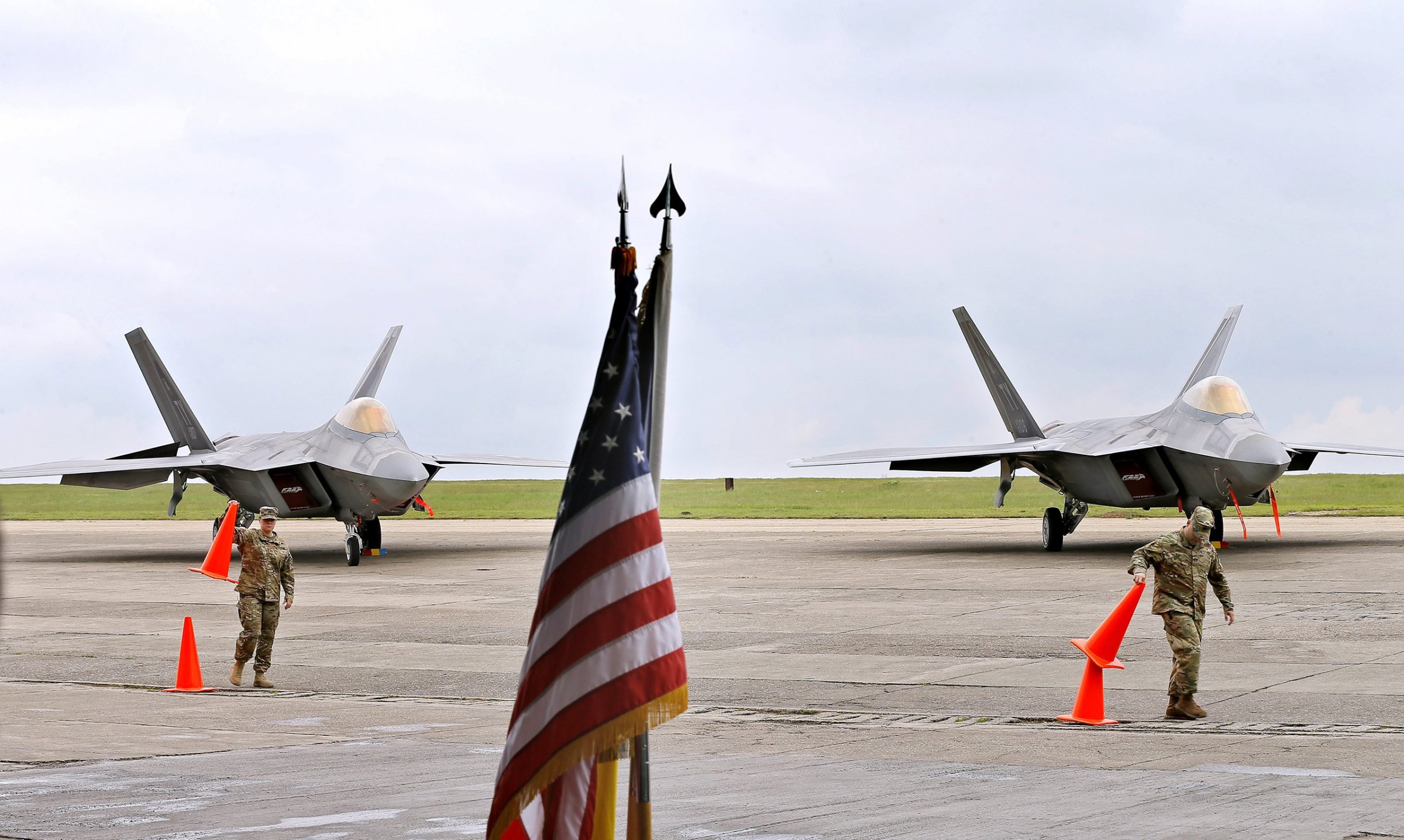 Romanian and US national flags in between two F22 Raptor jets of the US Air Force that landed at the Mijhail Kogalniceanu military airbase, near the Black Sea, Romania, April 25 2016.