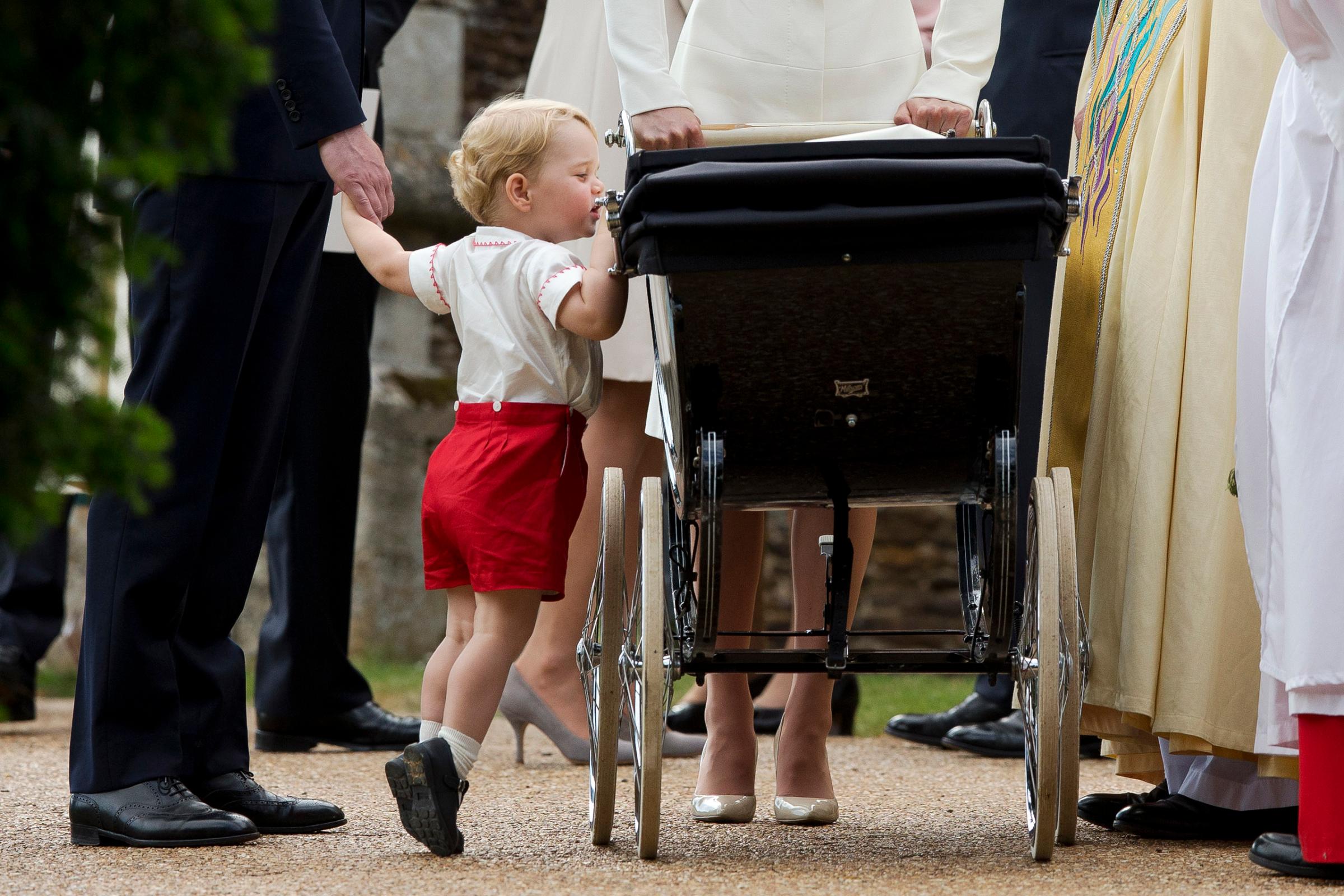 Catherine, Duchess of Cambridge and Prince William, Duke of Cambridge stand as Prince George of Cambridge looks into Princess Charlotte of Cambridge's pram as they leave the Church of St Mary Magdalene on the Sandringham Estate after the Christening of Princess Charlotte of Cambridge in King's Lynn, England on July 5, 2015.