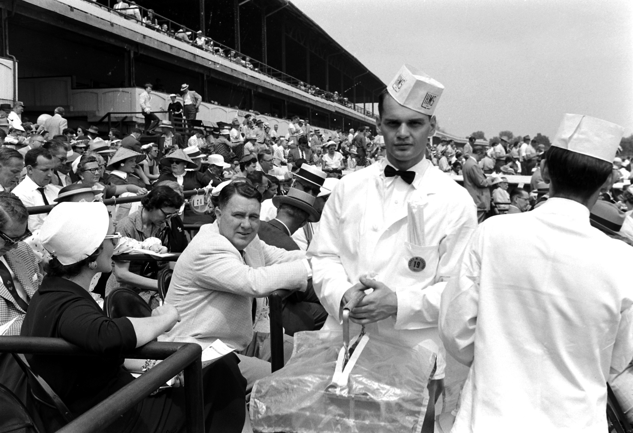 Waiters serve mint juleps to spectators at Churchill Downs on Derby day, 1960.