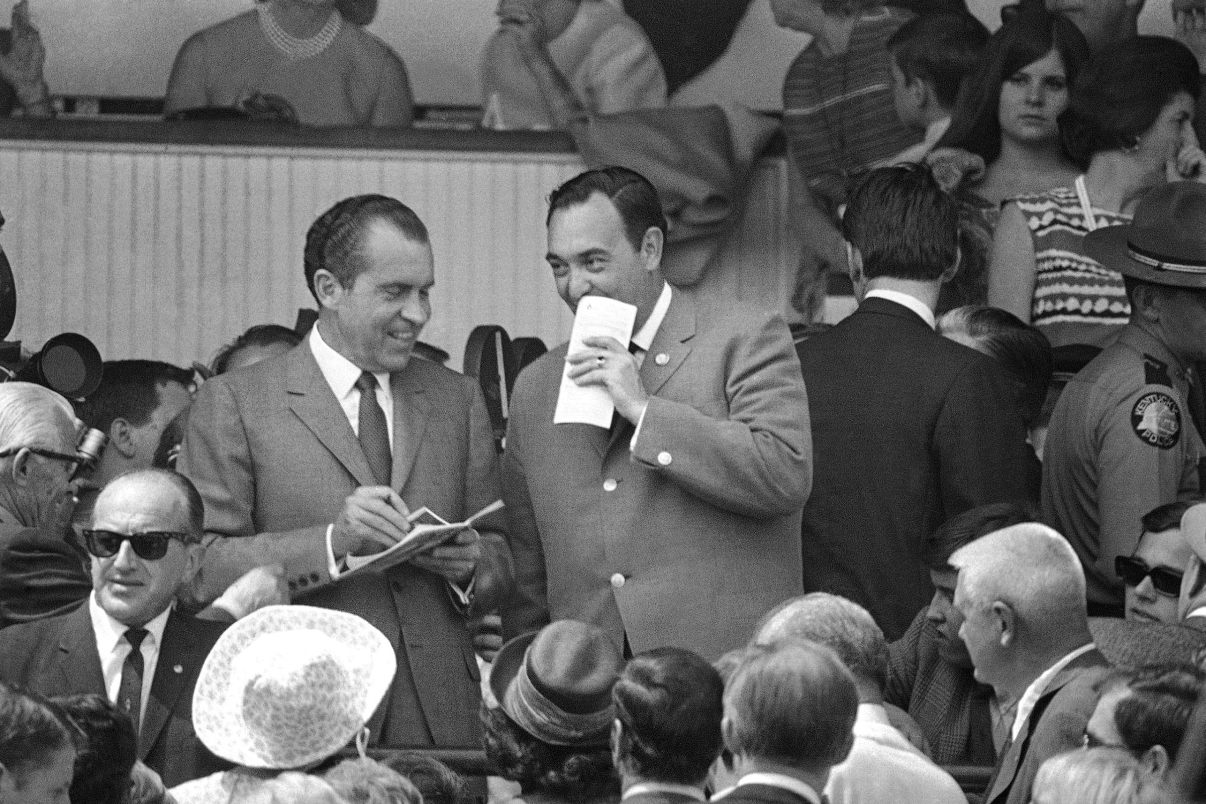 Kentucky Gov. Louie B. Nunn, right, raises his program to his face as he talks over the Kentucky Derby program with President Richard M. Nixon in the governor?s box at Churchill Downs in Louisville, Kentucky on May 3, 1969.