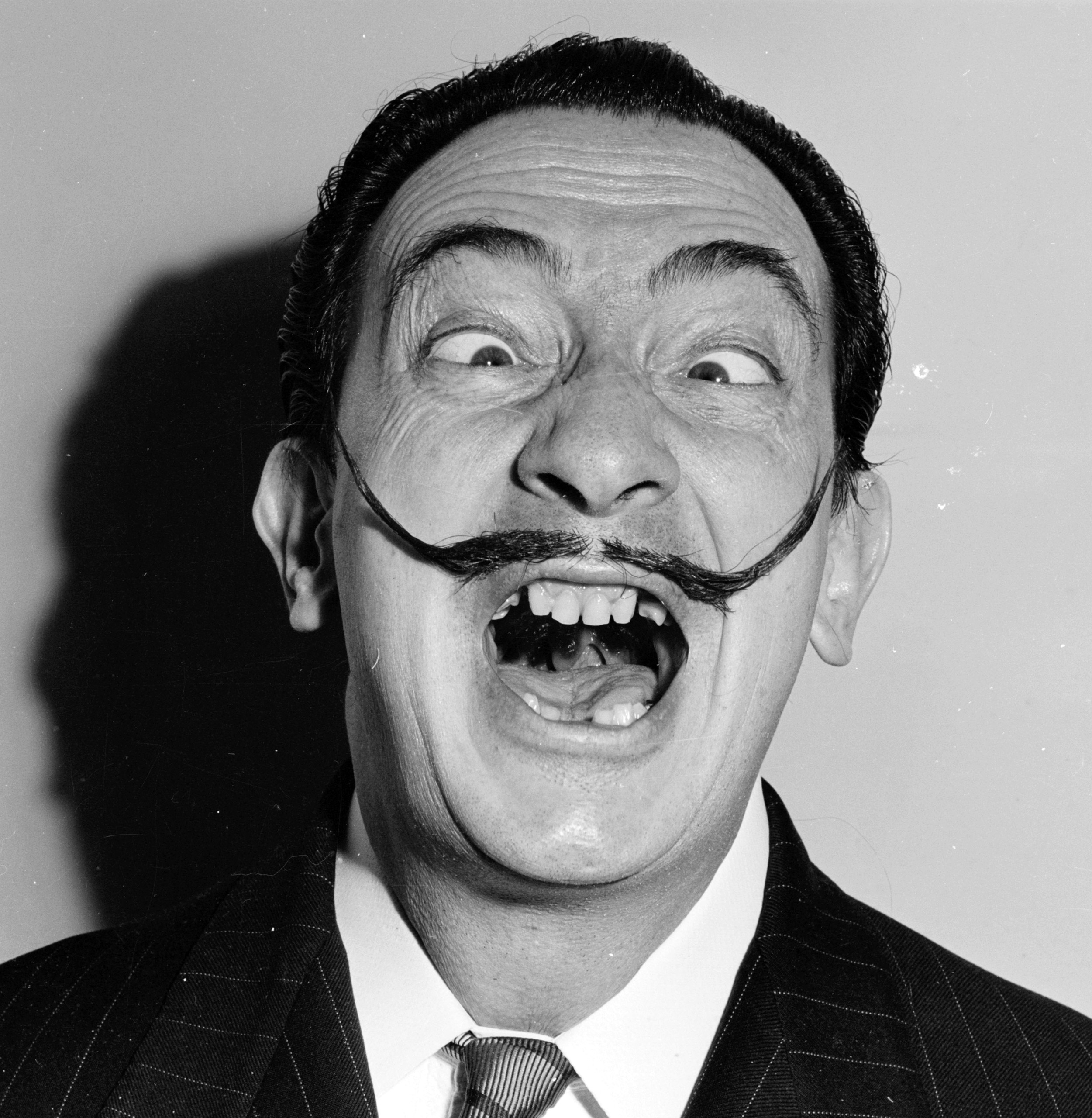 circa 1950:  Spanish surrealist artist Salvador Dali (1904 - 1989) shows off his famous moustache.  (Photo by Weegee(Arthur Fellig)/International Center of Photography/Getty Images)