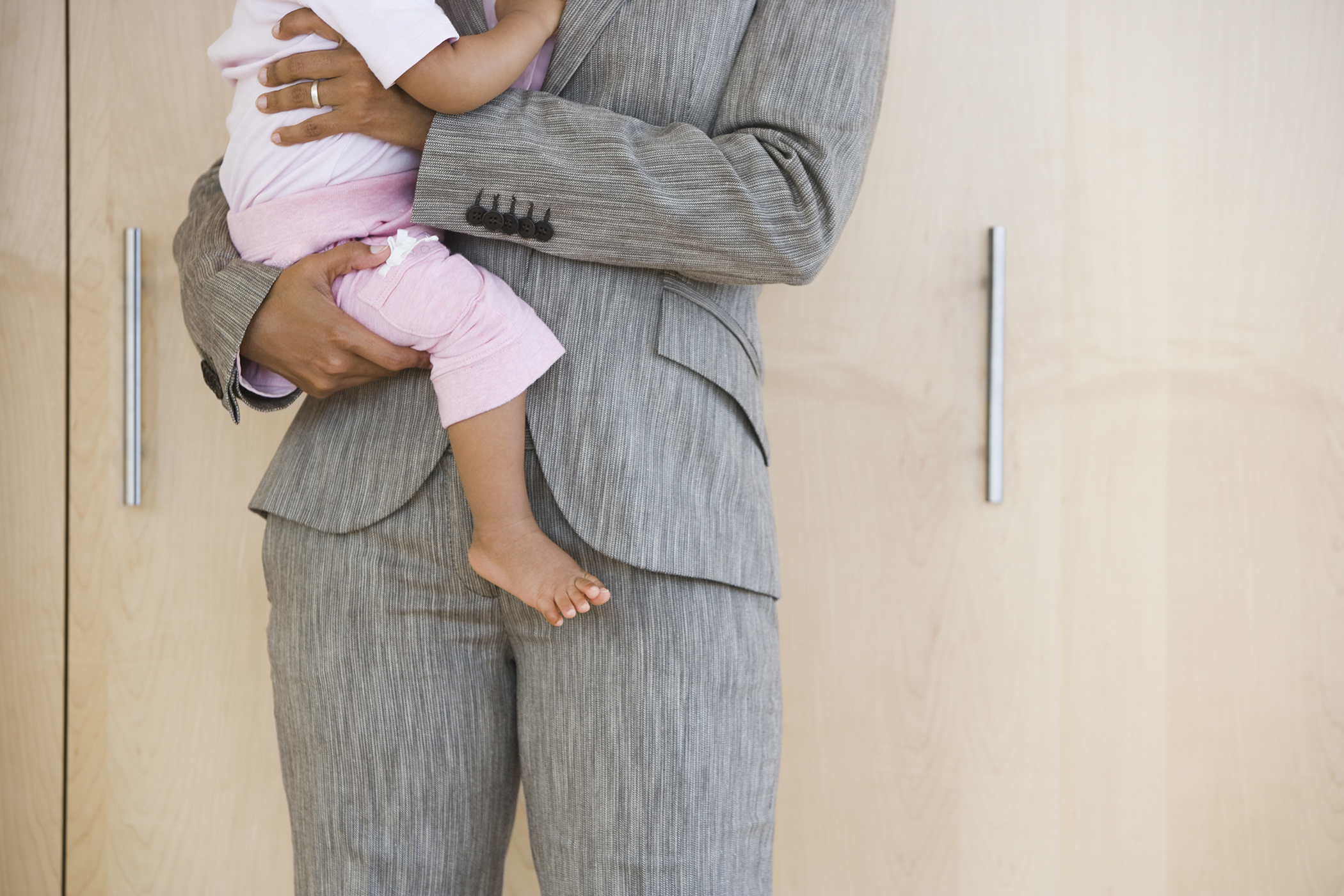 woman in business suit holding baby