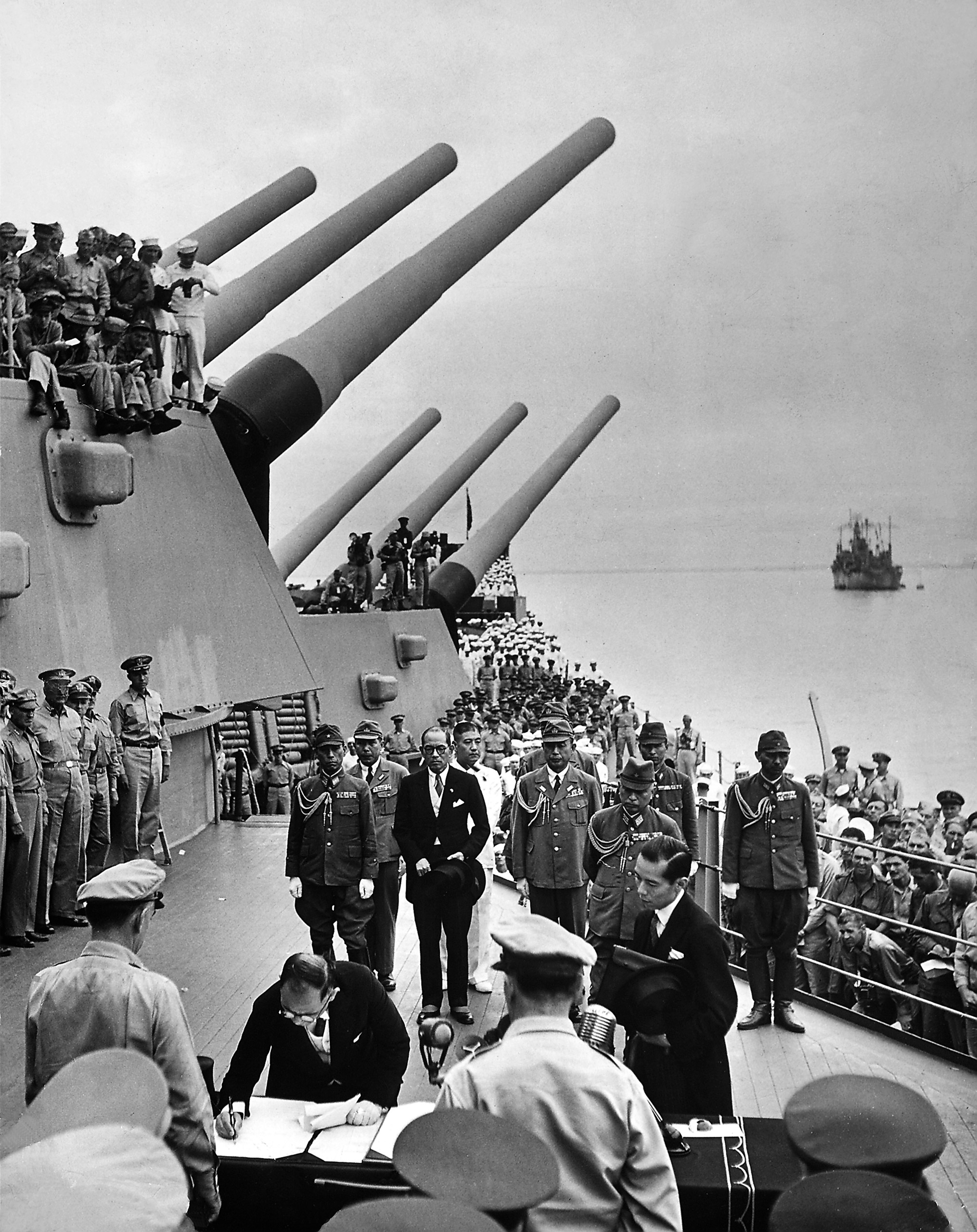 Allied officers and crew crowd decks of US battleship Missouri as senior Japanese delegate Mamoru Shigemitsu signs official surrender documents ending WWII. This image appeared in the Sept. 17, 1945 feature: Japan Signs the Surrender.