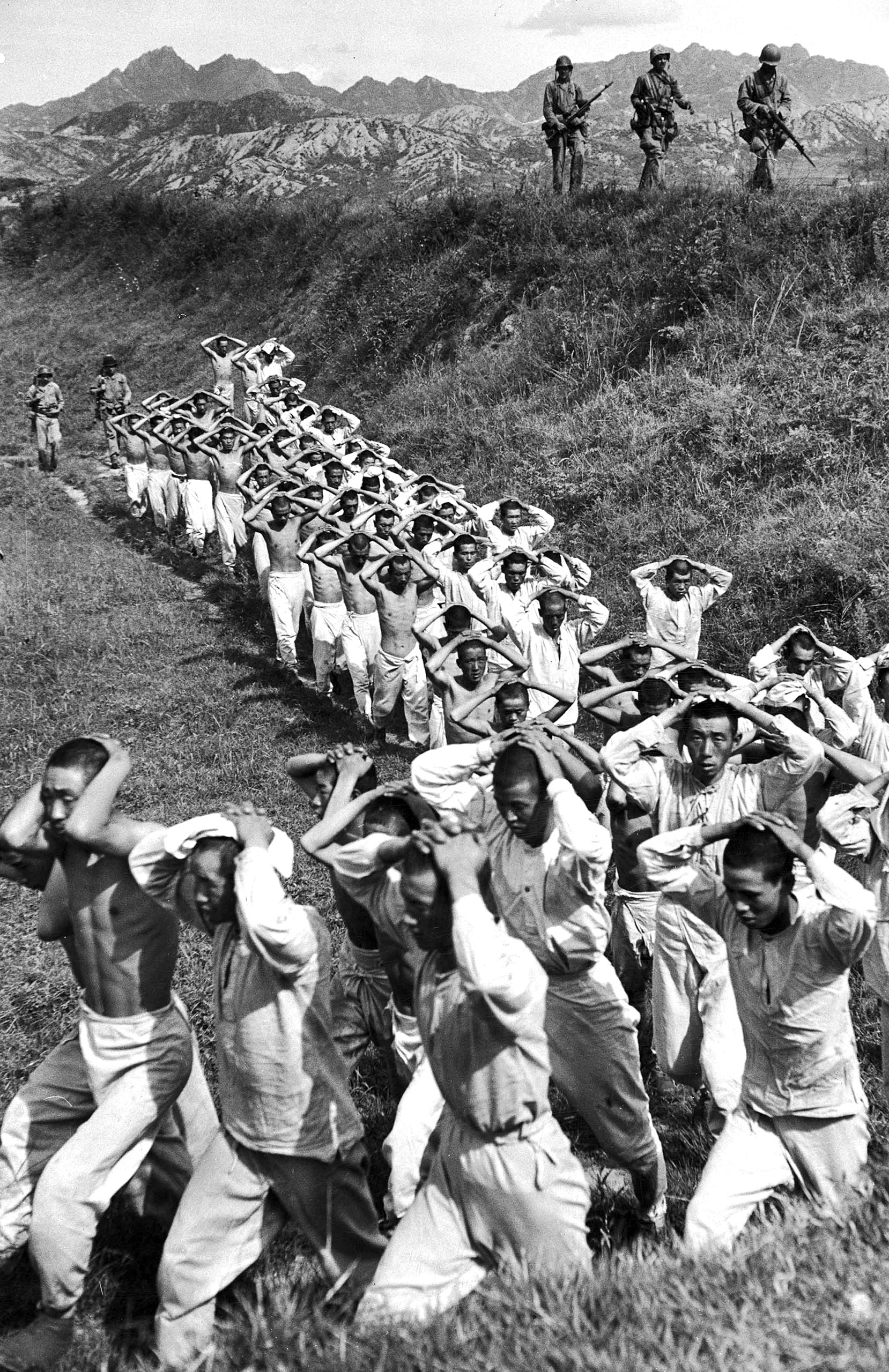 Communist prisoners stripped down to their underwear are marched to the rear by Marine guards. This image appeared in the Oct. 9, 1950 photo essay: Seoul and Victory—Here is record way South Korea was retaken.