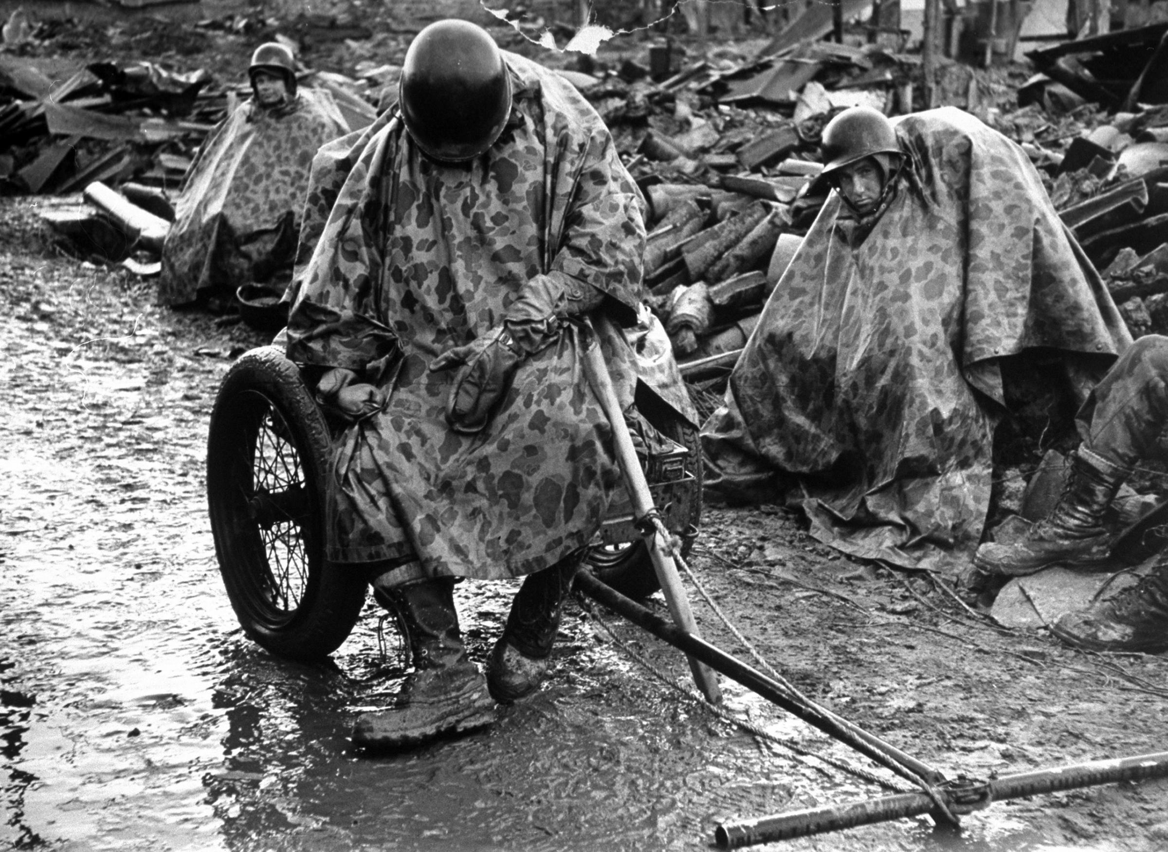 Exhausted Marine catching a nap while sitting on a cart full of ammunition. This image appeared in the March 12, 1951 photo essay: Gen. Matt and Gen. Mud—Waterlogged Marines join U.N.'s Operation Killer.