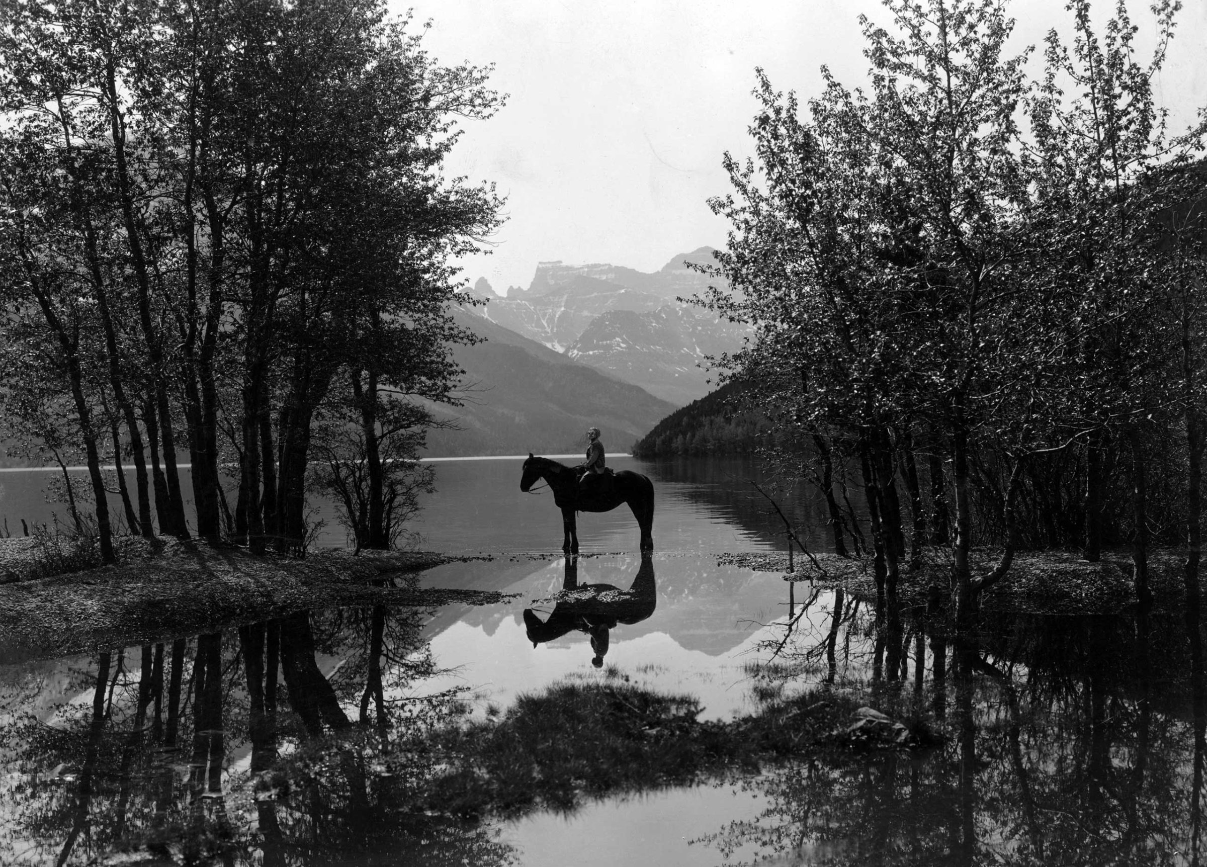 A rider on horseback in Waterton Lakes National Park, British Columbia. Circa 1930.