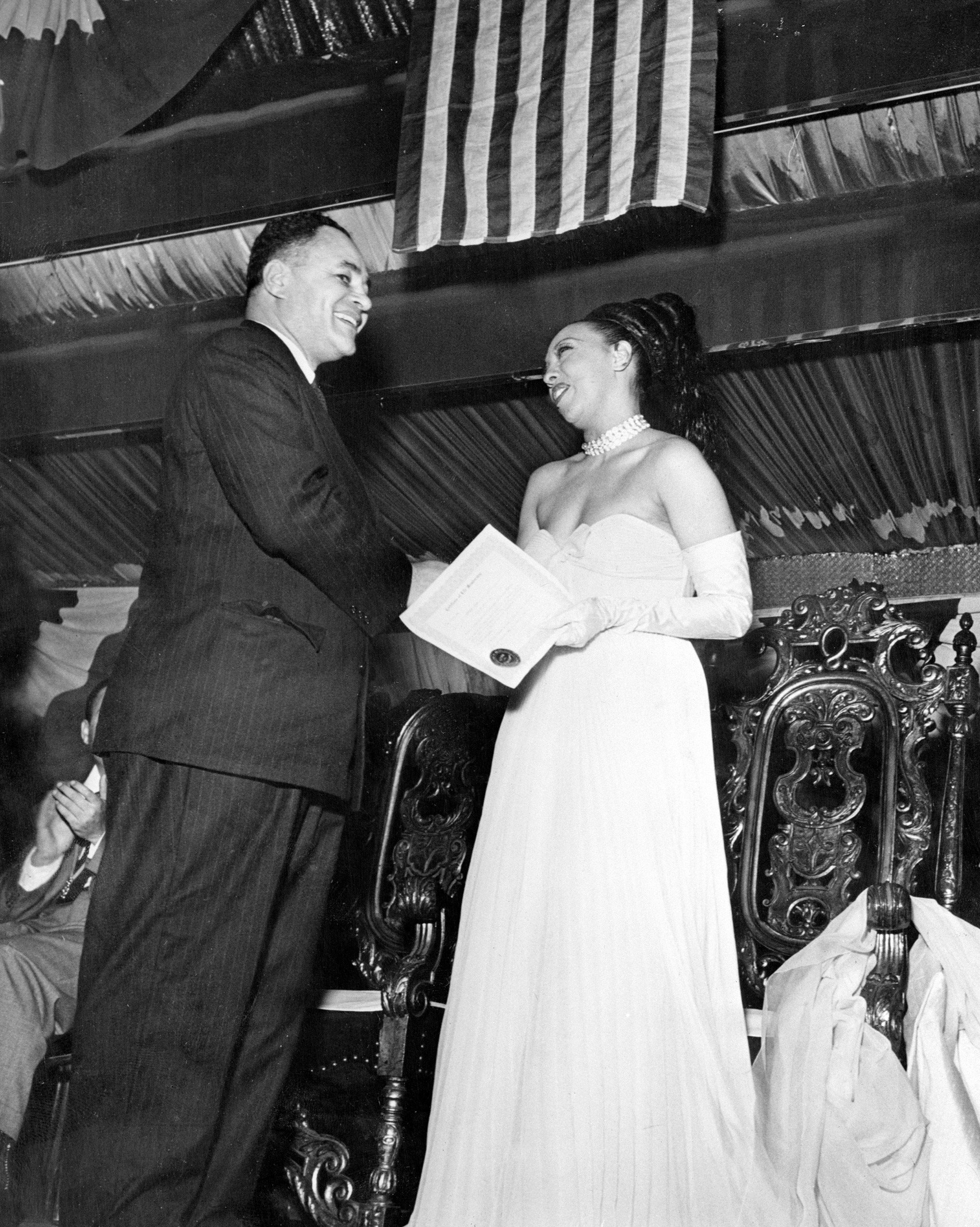 Dr. Ralph Bunche, former Palestine mediator and now director of United Nations trusteeship, serves as honorary chairman of "Jo Baker Day" honoring the well-known singer and entertainer. Dr. Bunche is shown presenting Miss Baker with Life Membership in the New York Branch of the NAACP, the sponsoring organization. 1950.