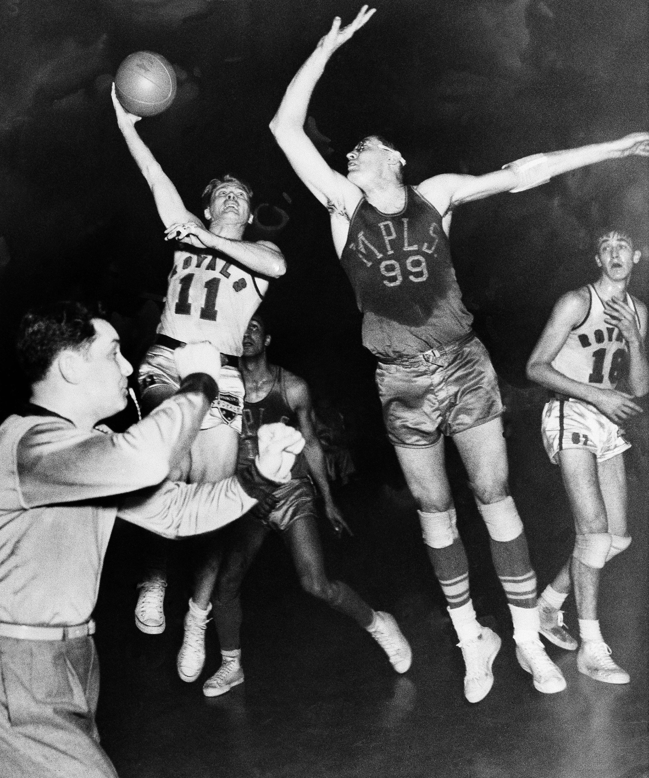 George Mikan (99), star Minneapolis Lakers center, breaks up a shot by Bob Davies, Rochester Royals guard (11) in the decisive game of the National Basketball Association's Western Division playoffs, April 4, 1951 in Rochester, N.Y. Rochester, won, 80-75.