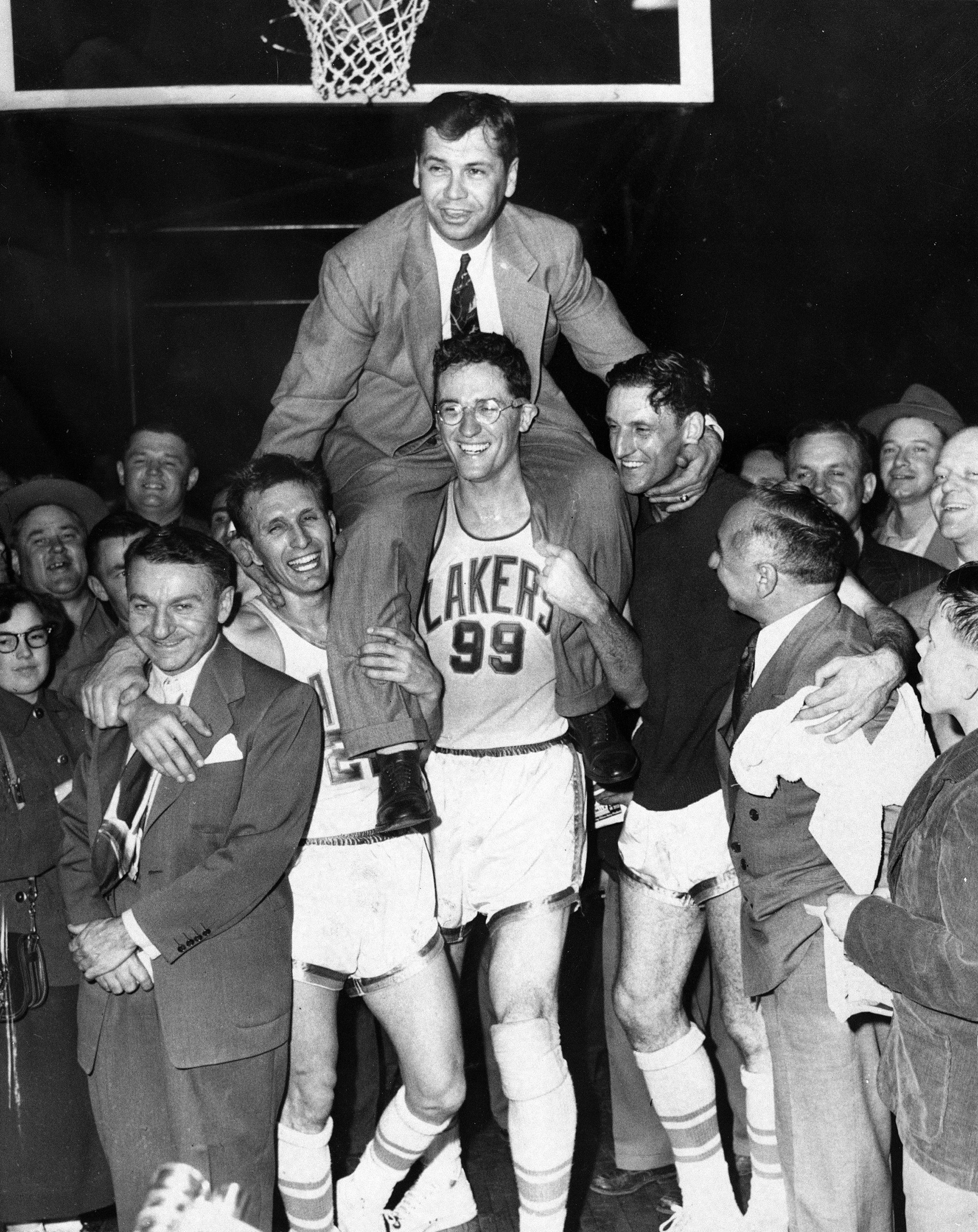 Minneapolis Lakers hoist coach John Kundla and carry him to their dressing room after beating the New York Knickebockers 82-65 April 25, 1952, and winning their fourth National Basketball Association title in five years.