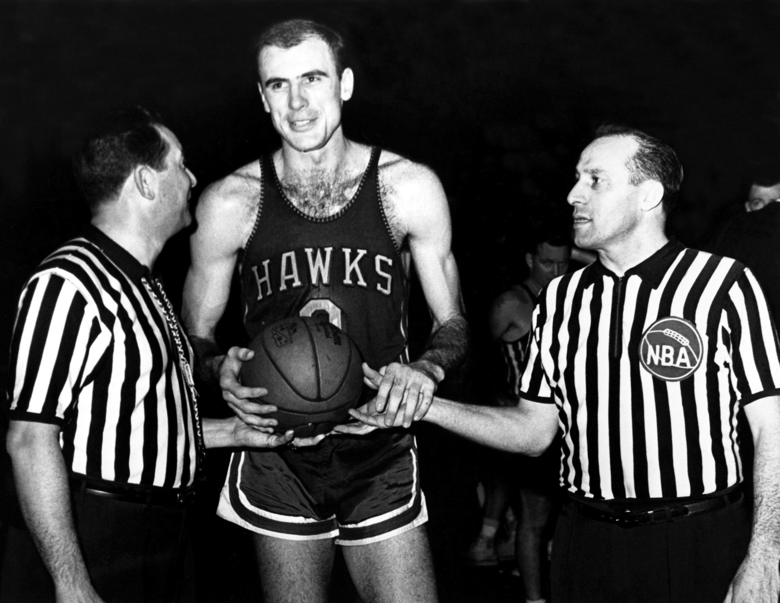 Bob Pettit of the St. Louis Hawks poses for a  portrait with referees circa 1955.