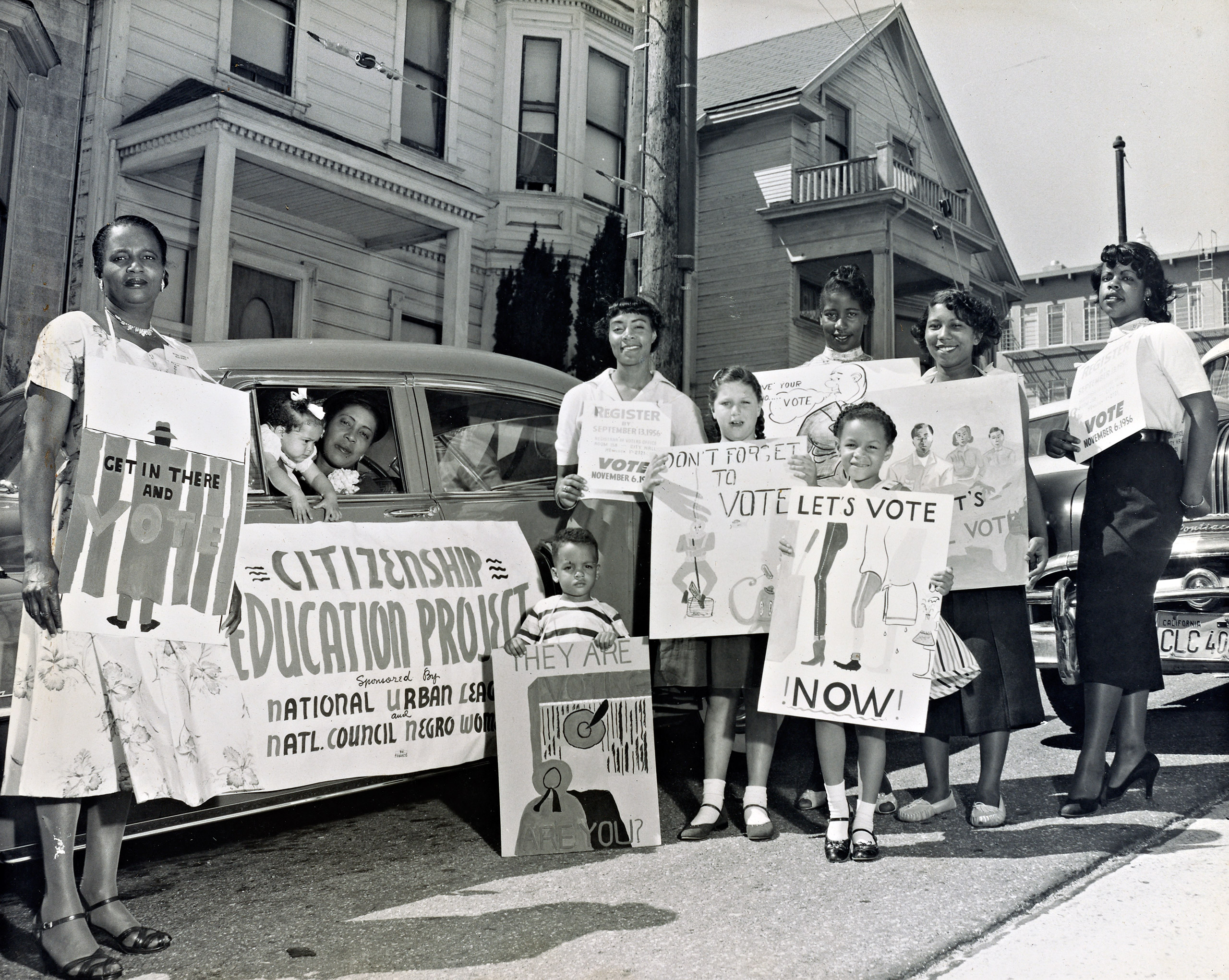 Young children and members of the San Francisco Chapter of the National Council of Negro Women with placards standing next to a car that was part of the Citizenship Education Project motorcade urging people to register to vote. Sept. 8, 1956.
