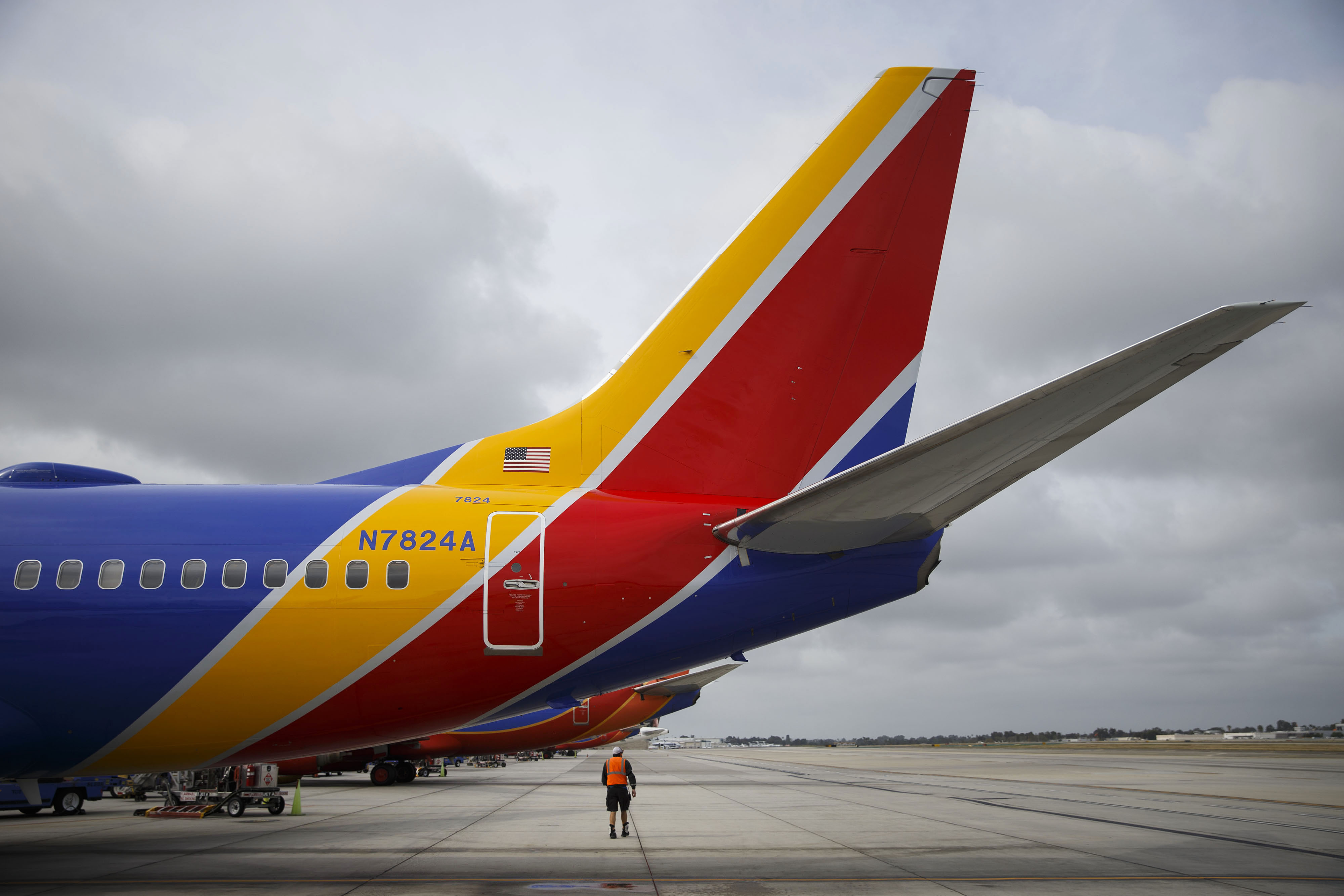 A Southwest Airlines Co. employee walks underneath the tail of a Boeing Co. 737 aircraft on the tarmac at John Wayne Airport (SNA) in Santa Ana, California, on April 14, 2016. (Patrick T. Fallon—Bloomberg/Getty Images)
